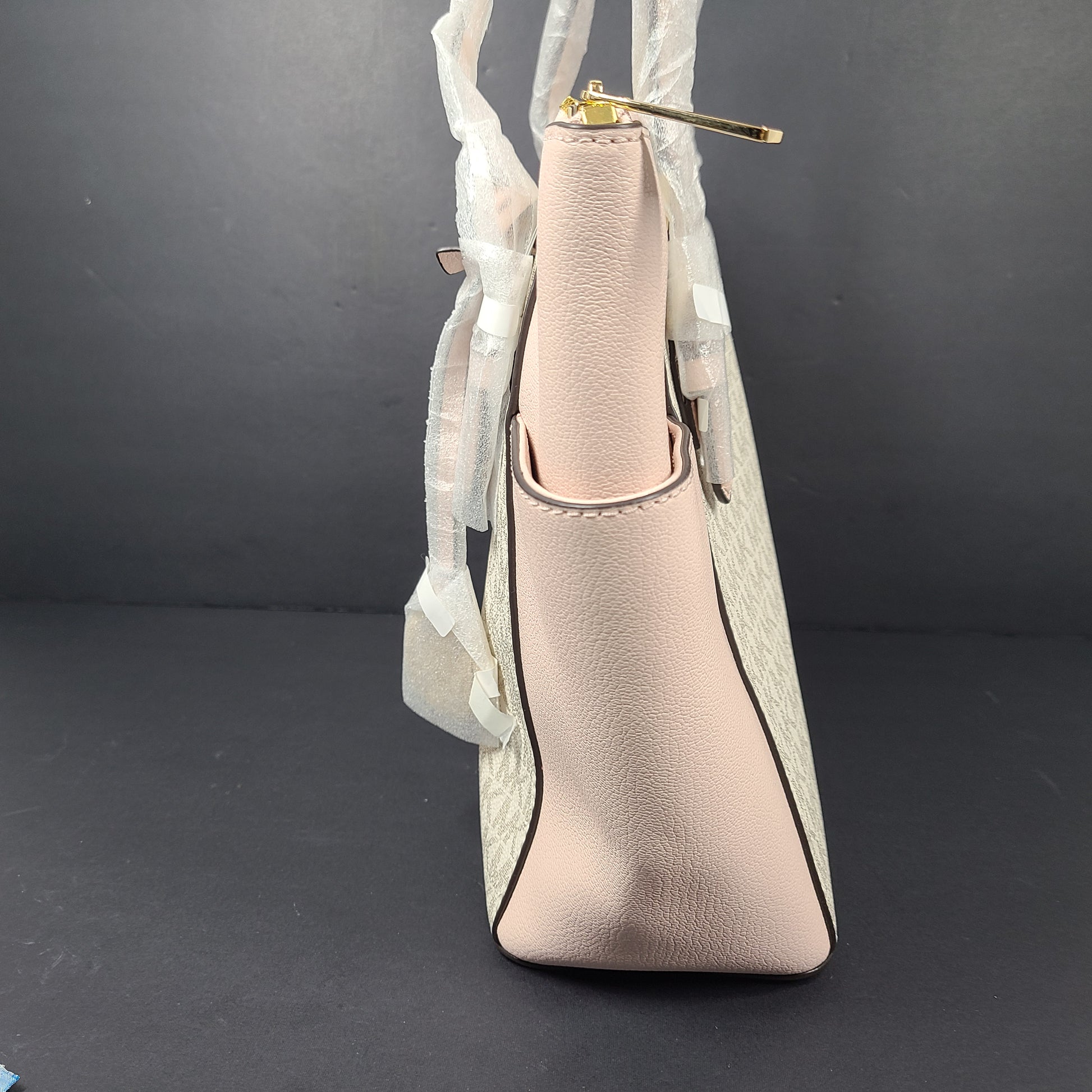 Light pink and logo canvas Michael Kors tote bag with gold zip and side pockets, shown with handles