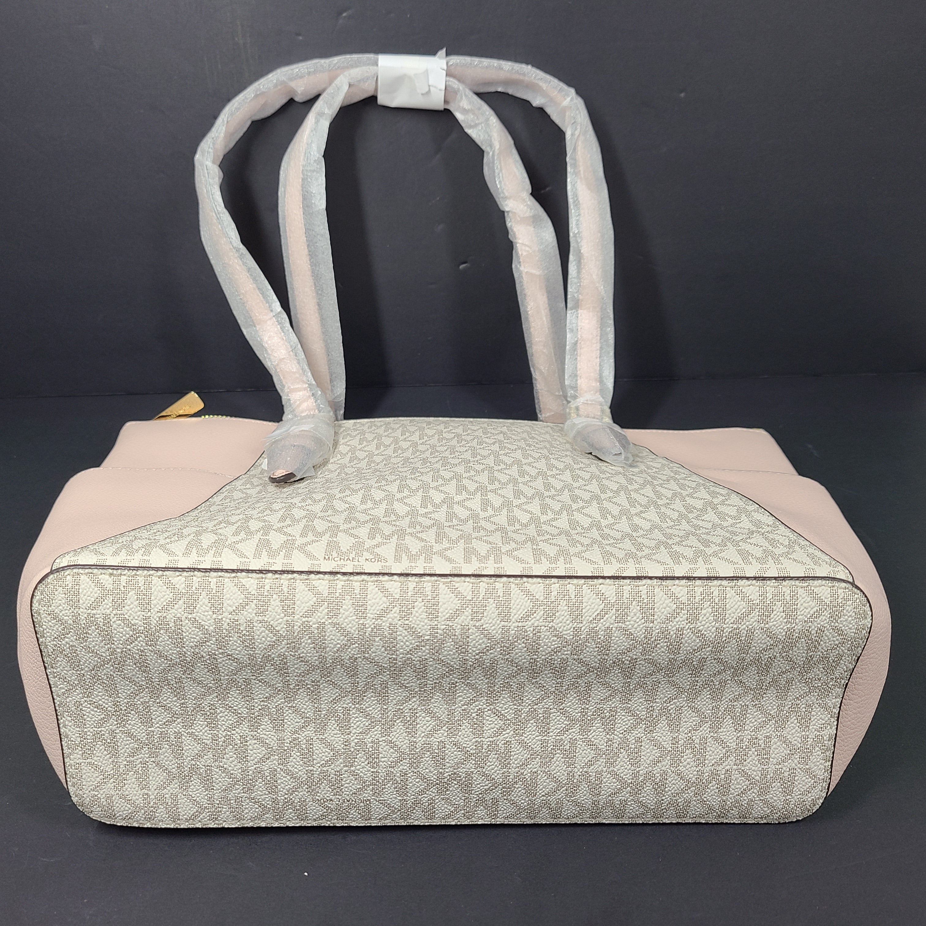 Light pink and logo canvas Michael Kors tote bag with gold zip and side pockets, shown with handles