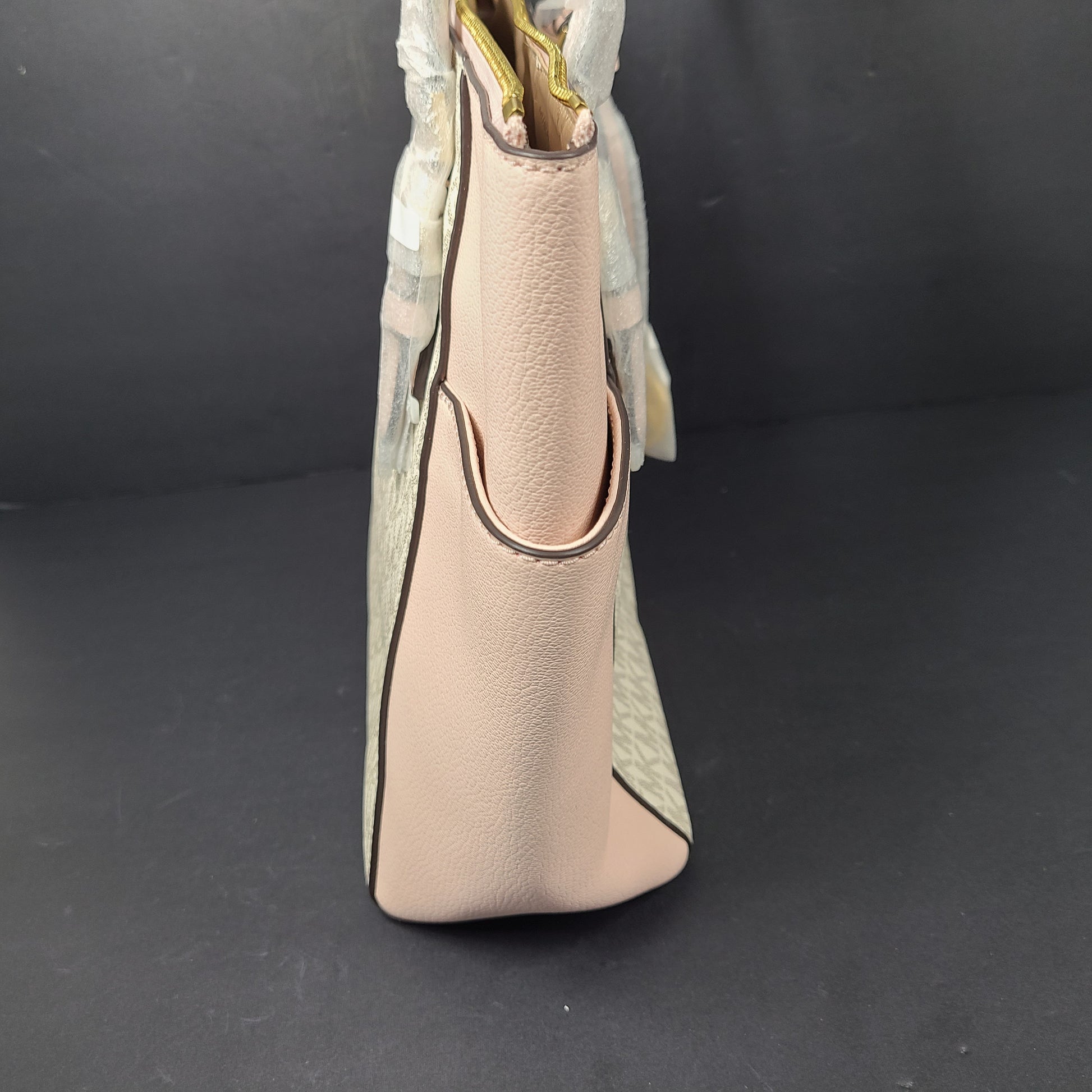 Light pink and logo canvas Michael Kors tote bag with gold zip and side pockets, shown with handles