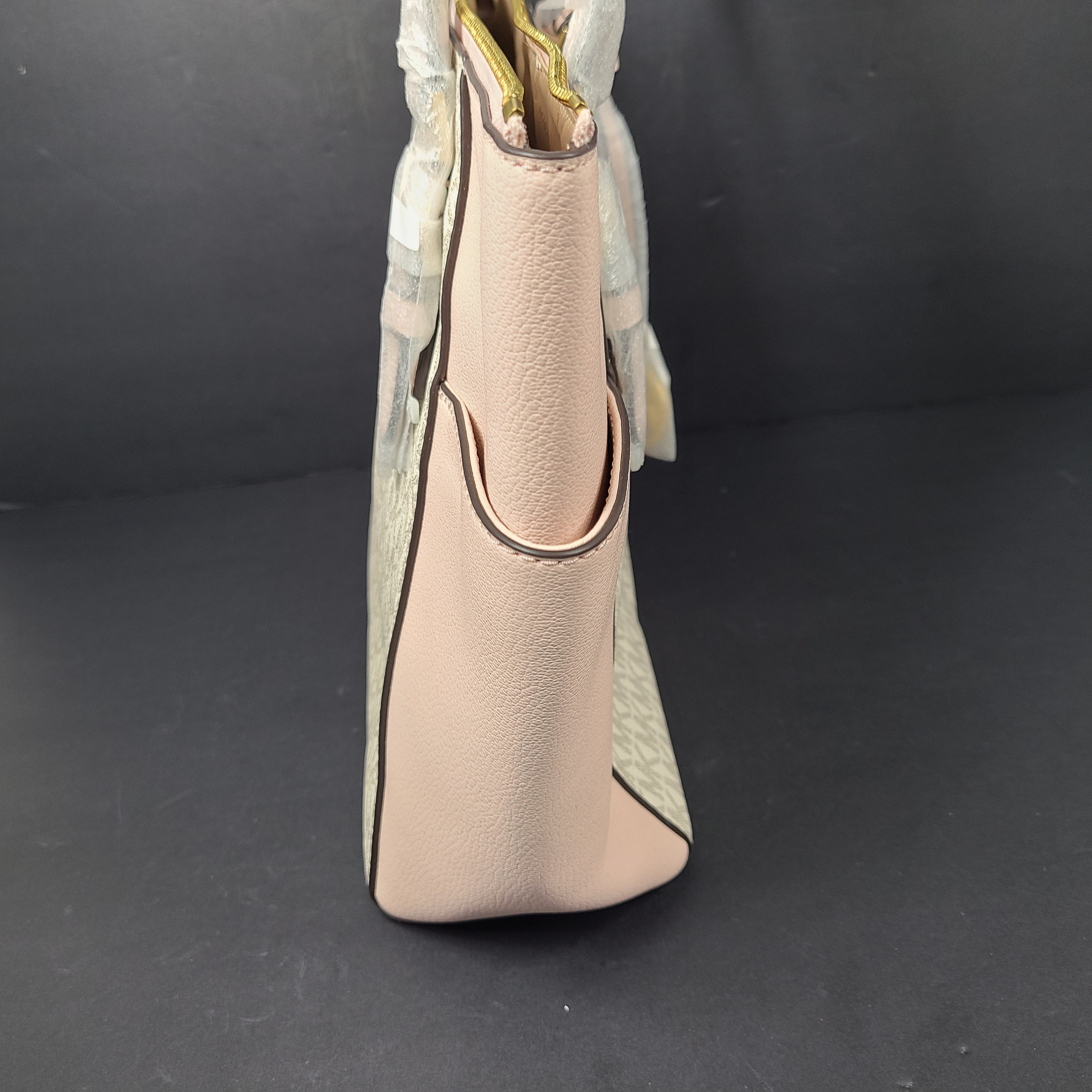 Light pink and logo canvas Michael Kors tote bag with gold zip and side pockets, shown with handles