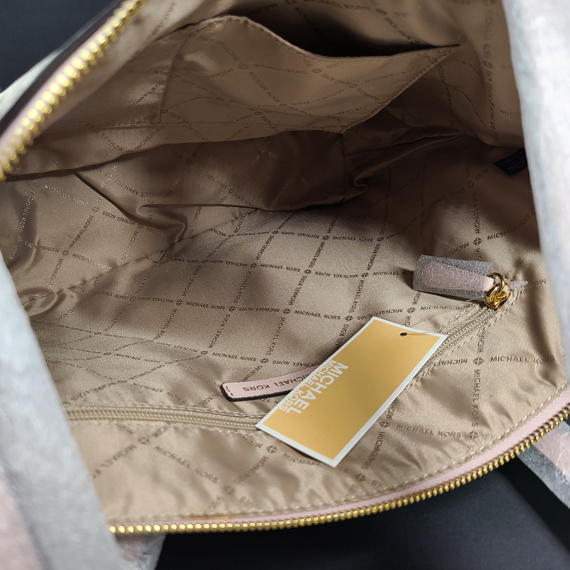 Light pink and logo canvas Michael Kors tote bag with gold zip and side pockets, shown with handles