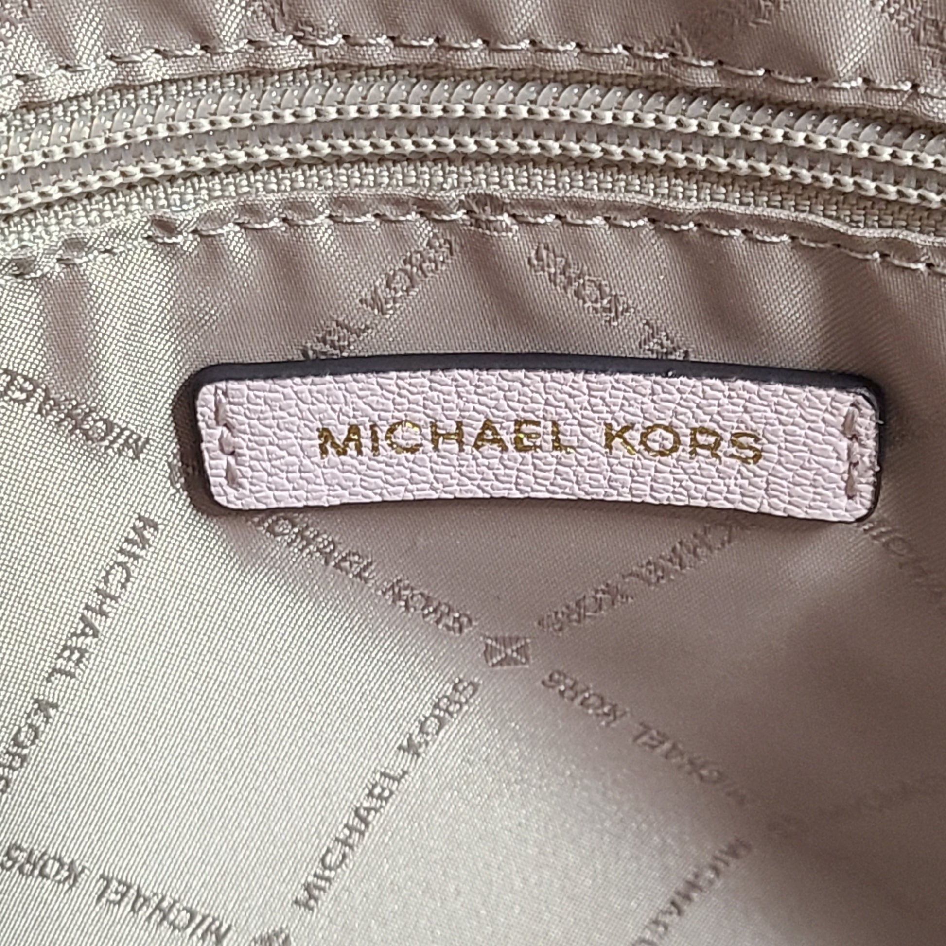 Light pink and logo canvas Michael Kors tote bag with gold zip and side pockets, shown with handles