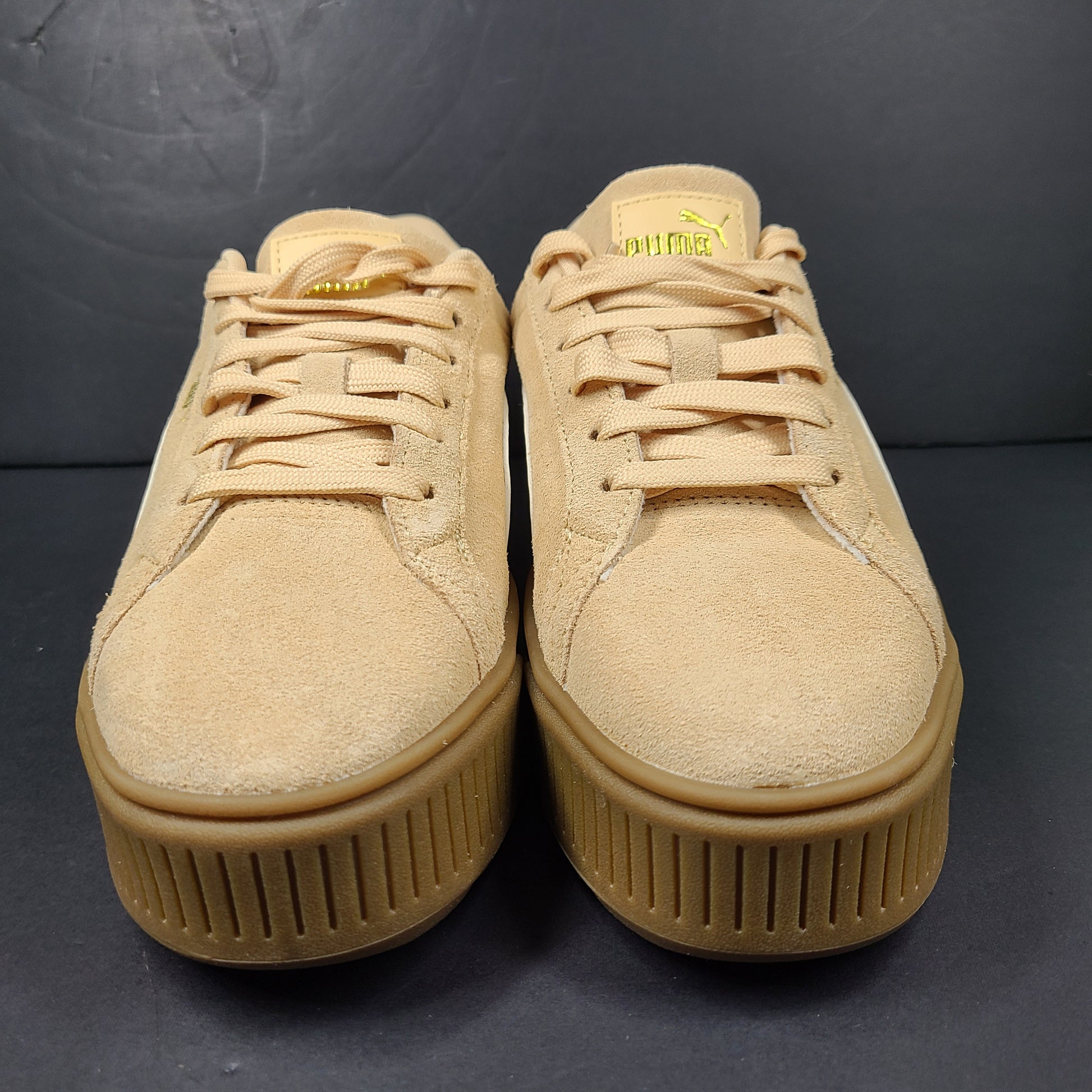A pair of beige Puma Women's Suede Platform Sneakers.