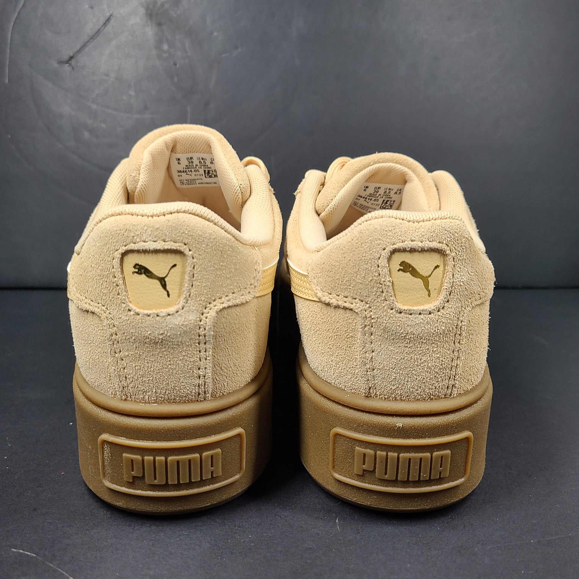A pair of beige Puma Women's Suede Platform Sneakers.