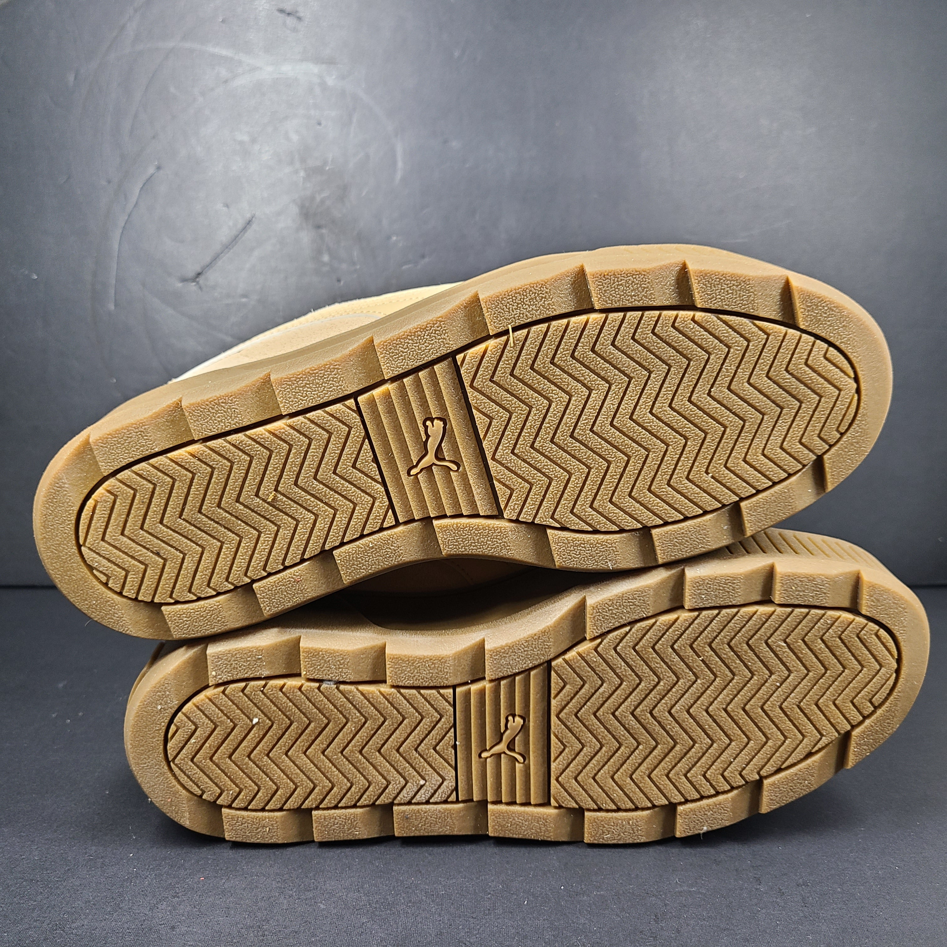 A pair of beige Puma Women's Suede Platform Sneakers.