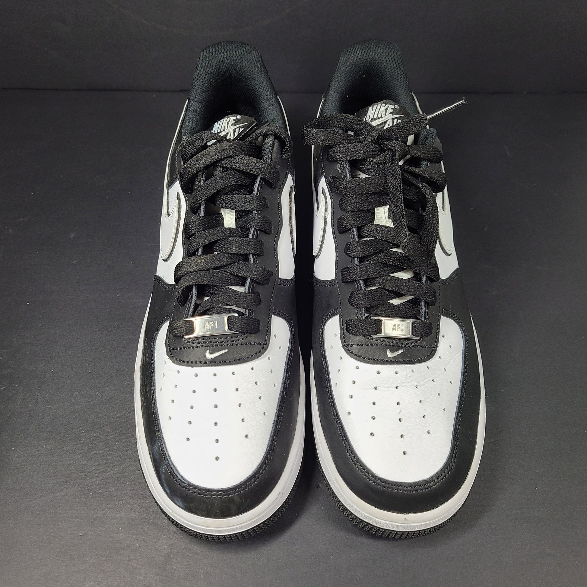 A stylish pair of Nike Air Force 1 Low sneakers in black and white.