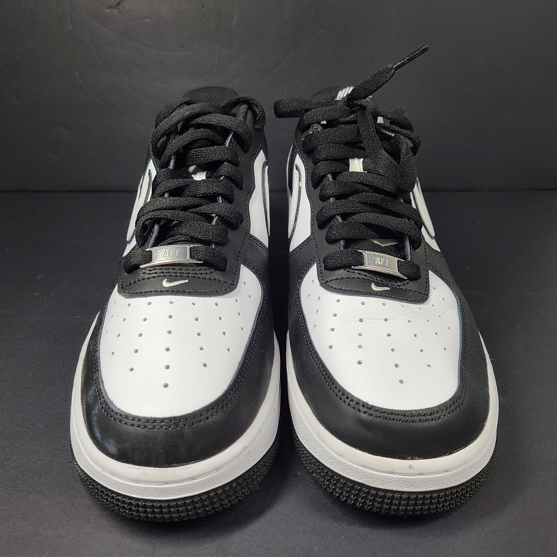A stylish pair of Nike Air Force 1 Low sneakers in black and white.