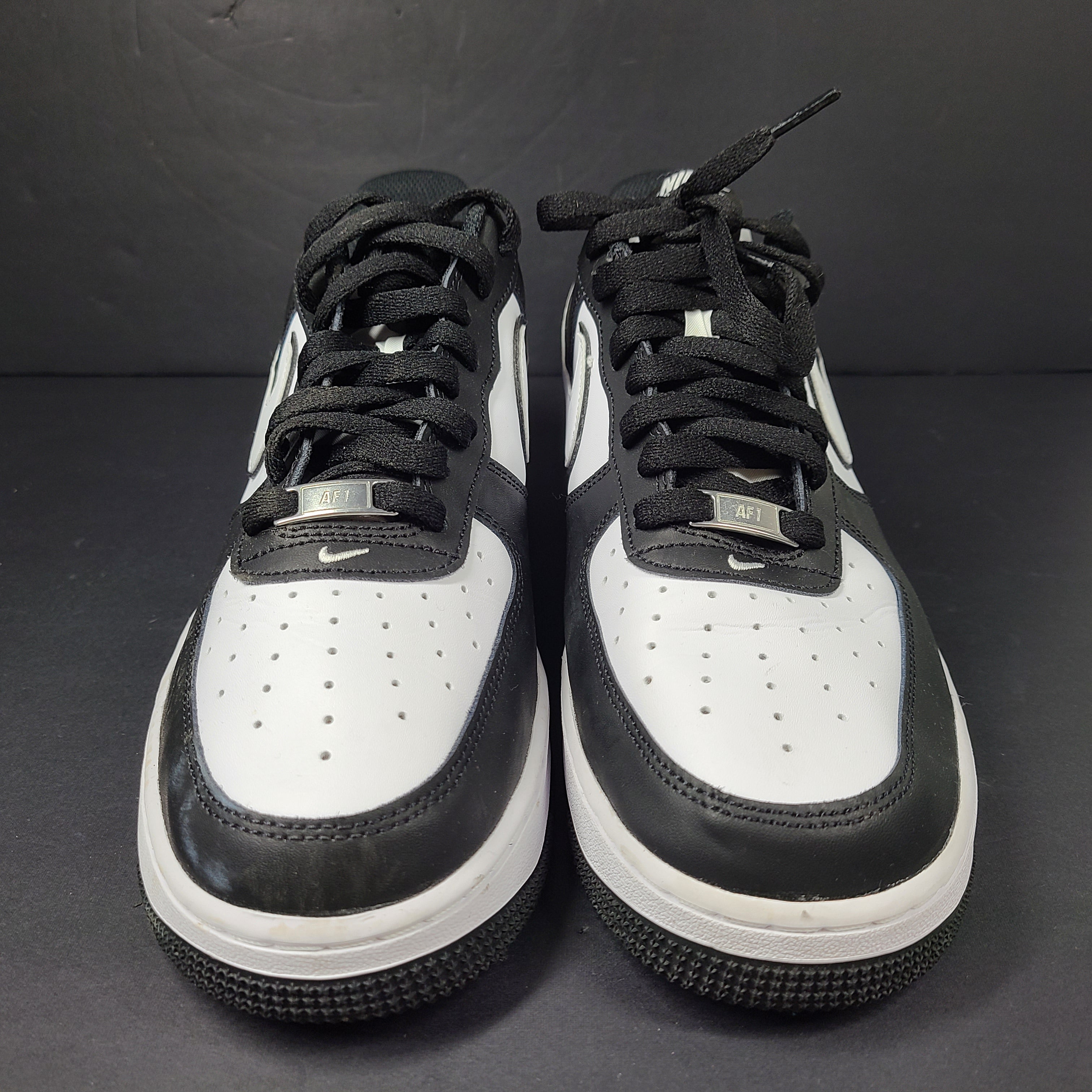 A stylish pair of Nike Air Force 1 Low sneakers in black and white.