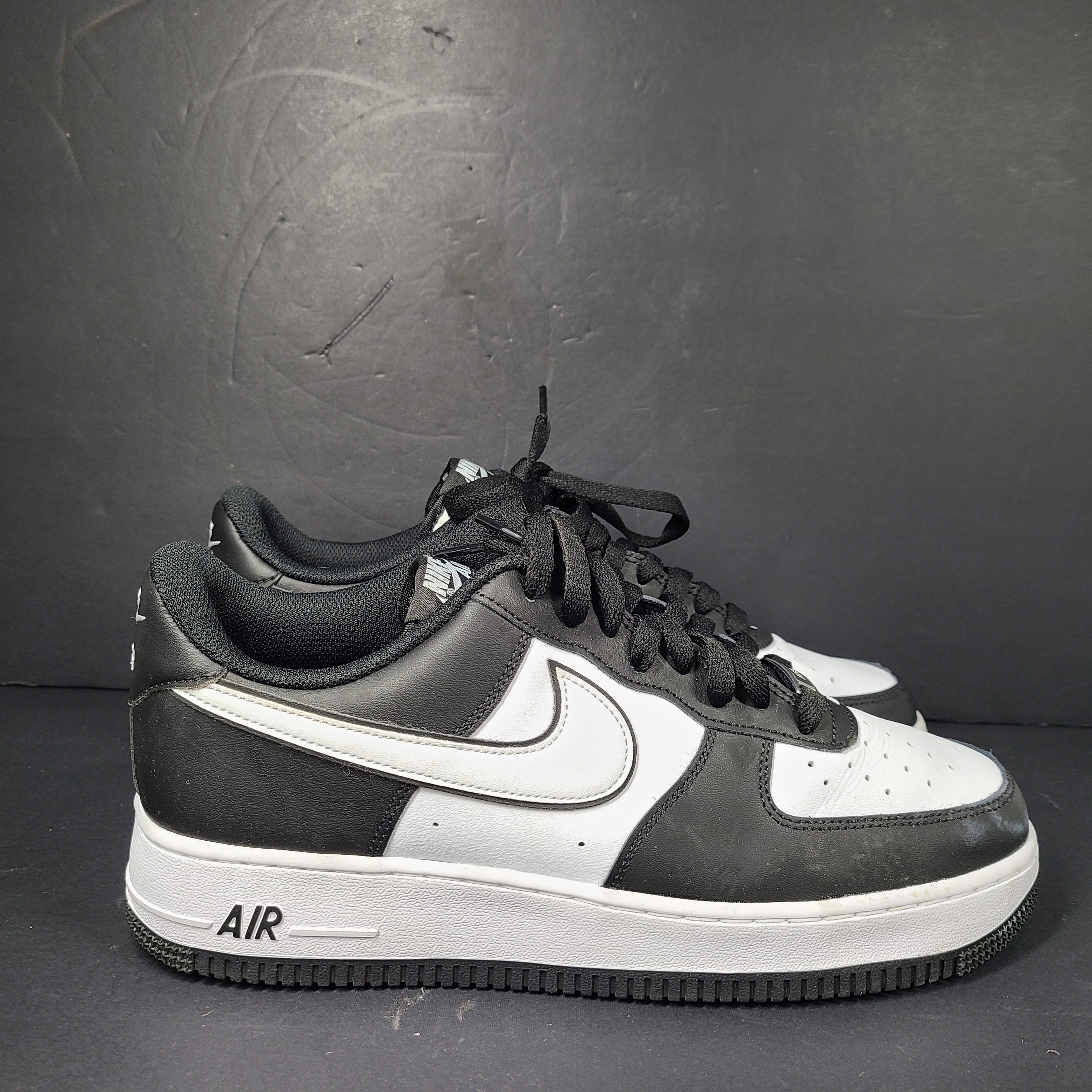 A stylish pair of Nike Air Force 1 Low sneakers in black and white.