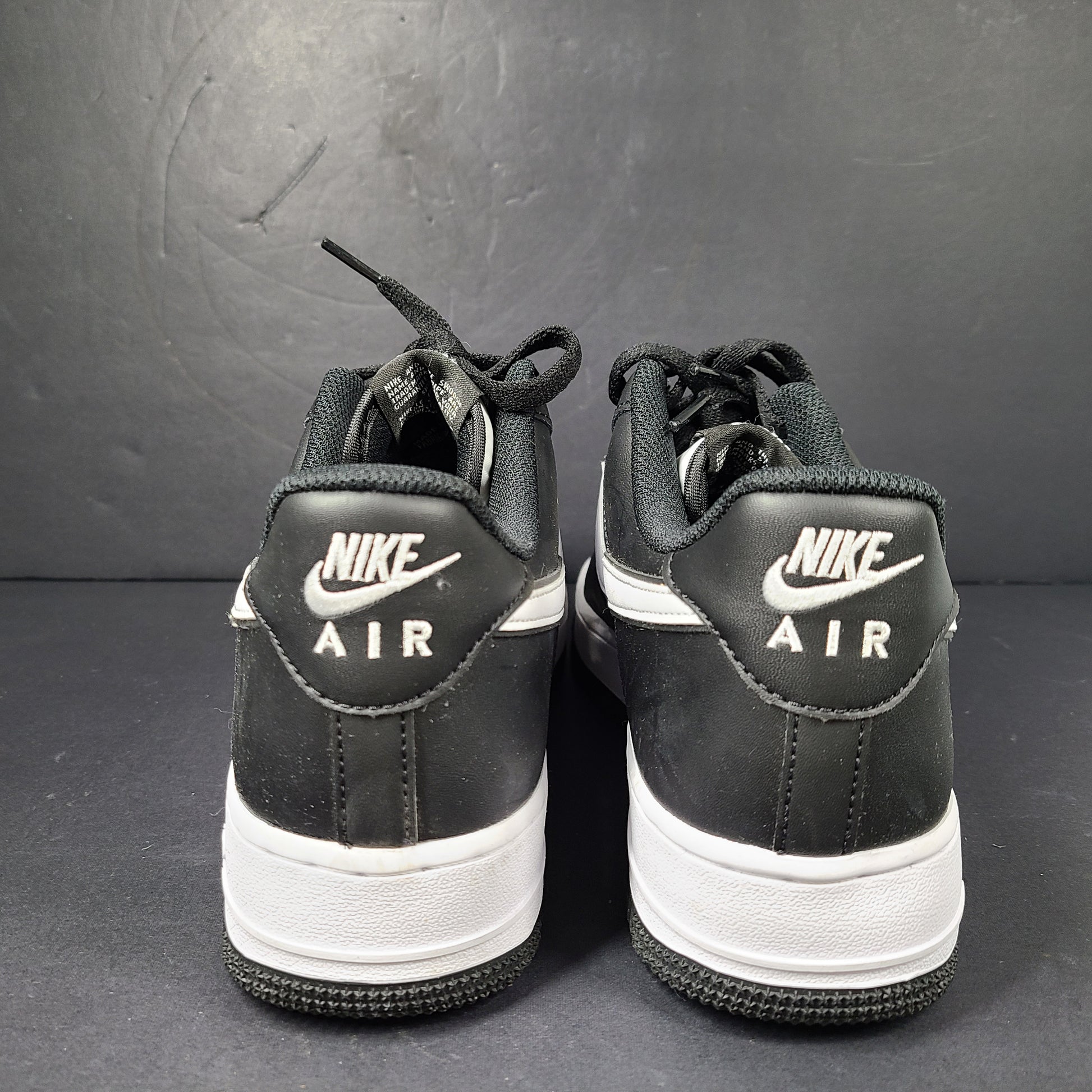 A stylish pair of Nike Air Force 1 Low sneakers in black and white.