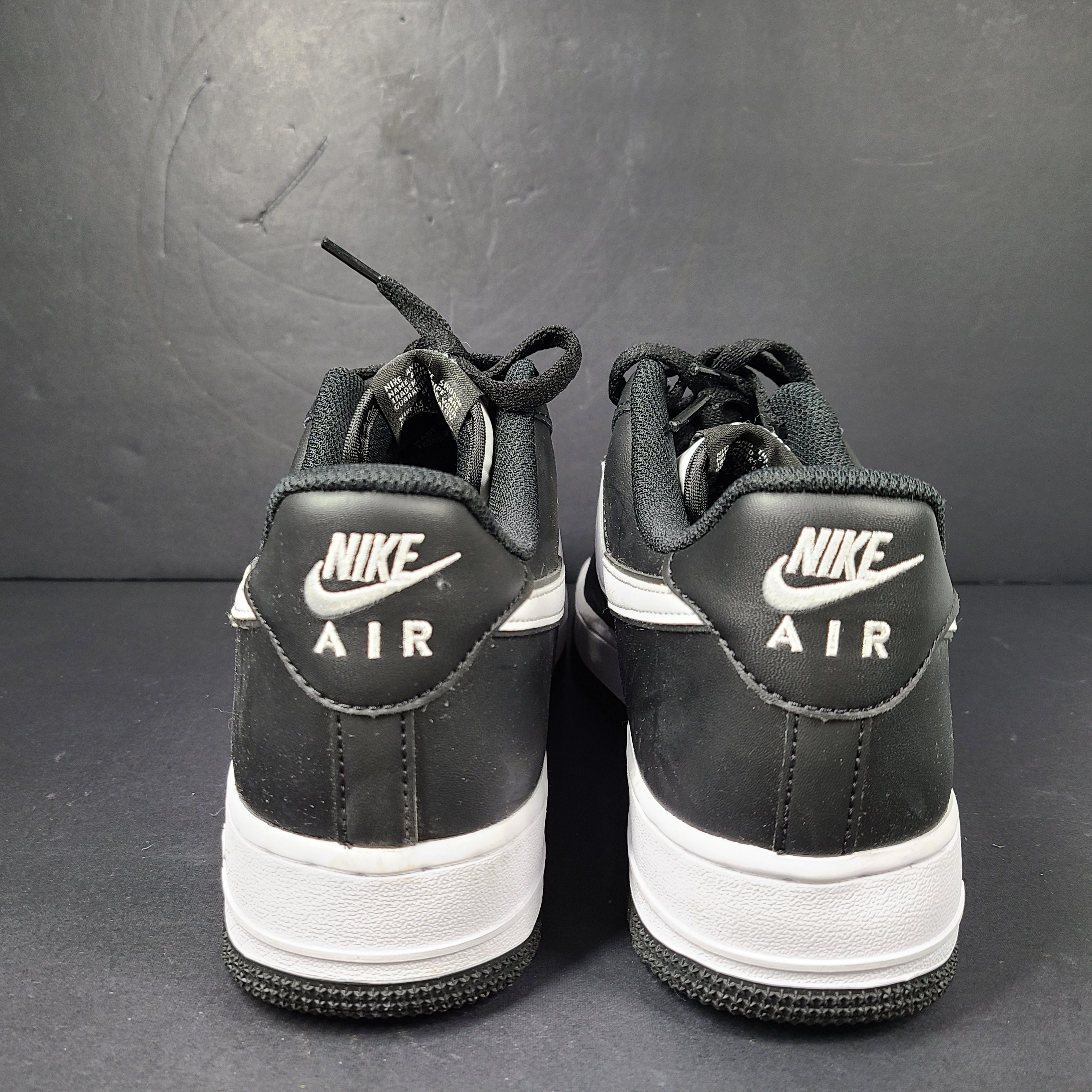 A stylish pair of Nike Air Force 1 Low sneakers in black and white.