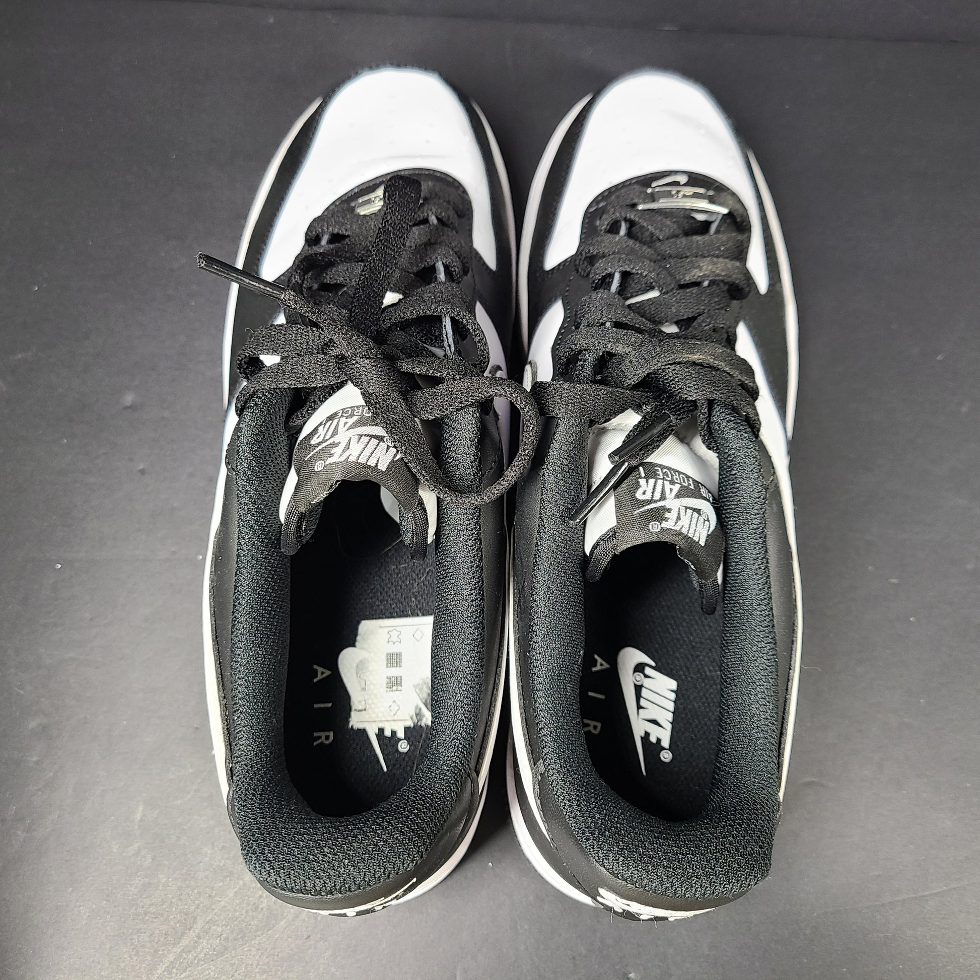 A stylish pair of Nike Air Force 1 Low sneakers in black and white.