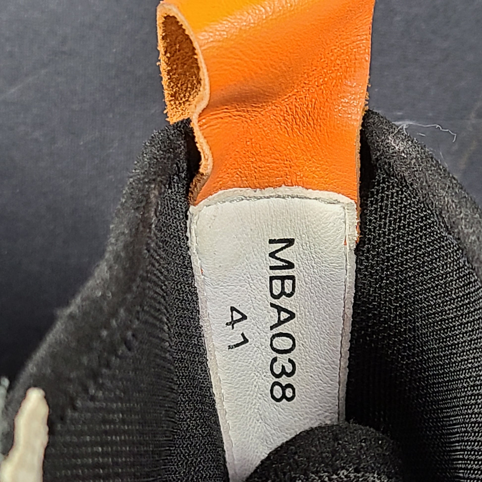 A pair of black and orange high top sneakers with Sz 41 for men.