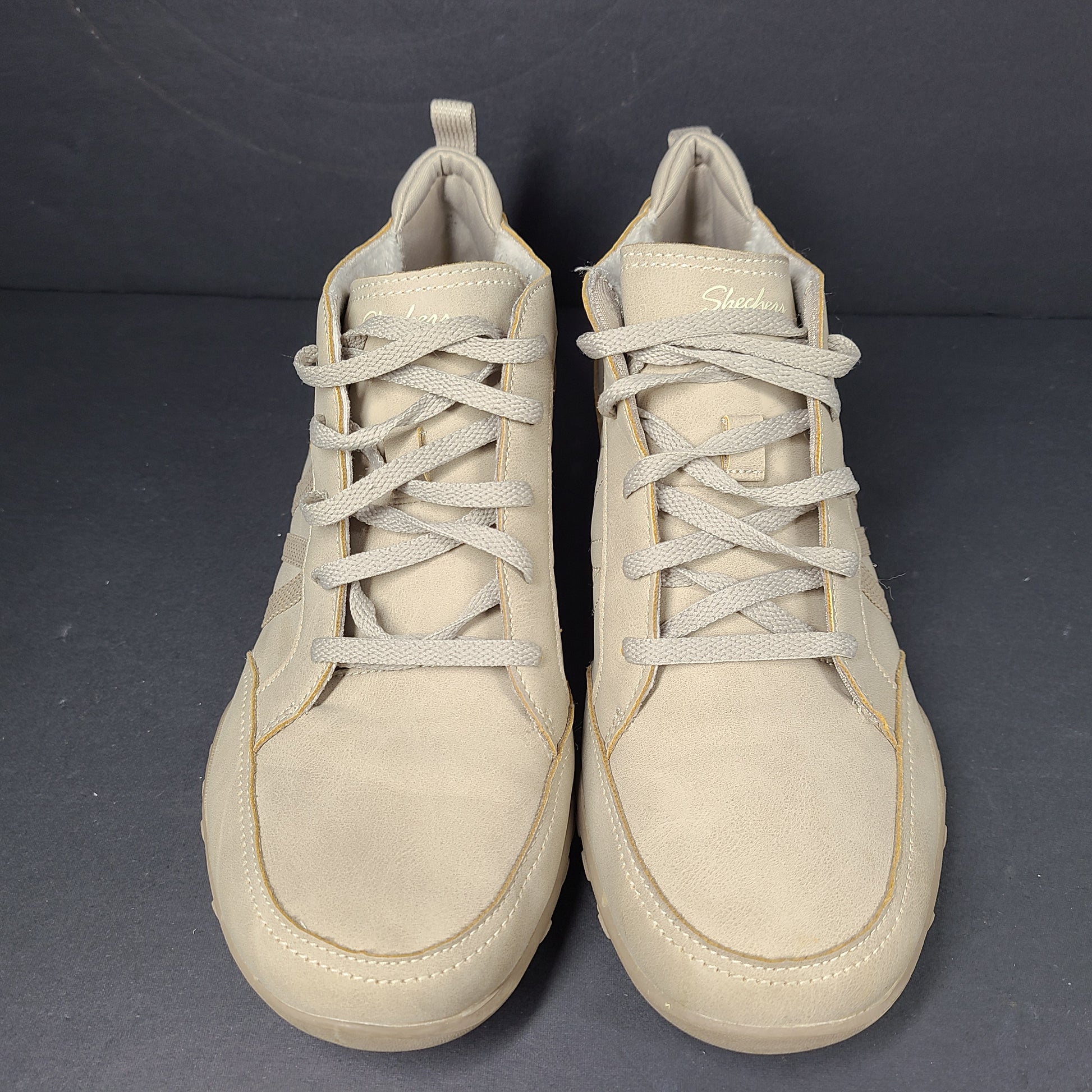 A pair of beige Skechers women's sneakers with a relaxed fit design.