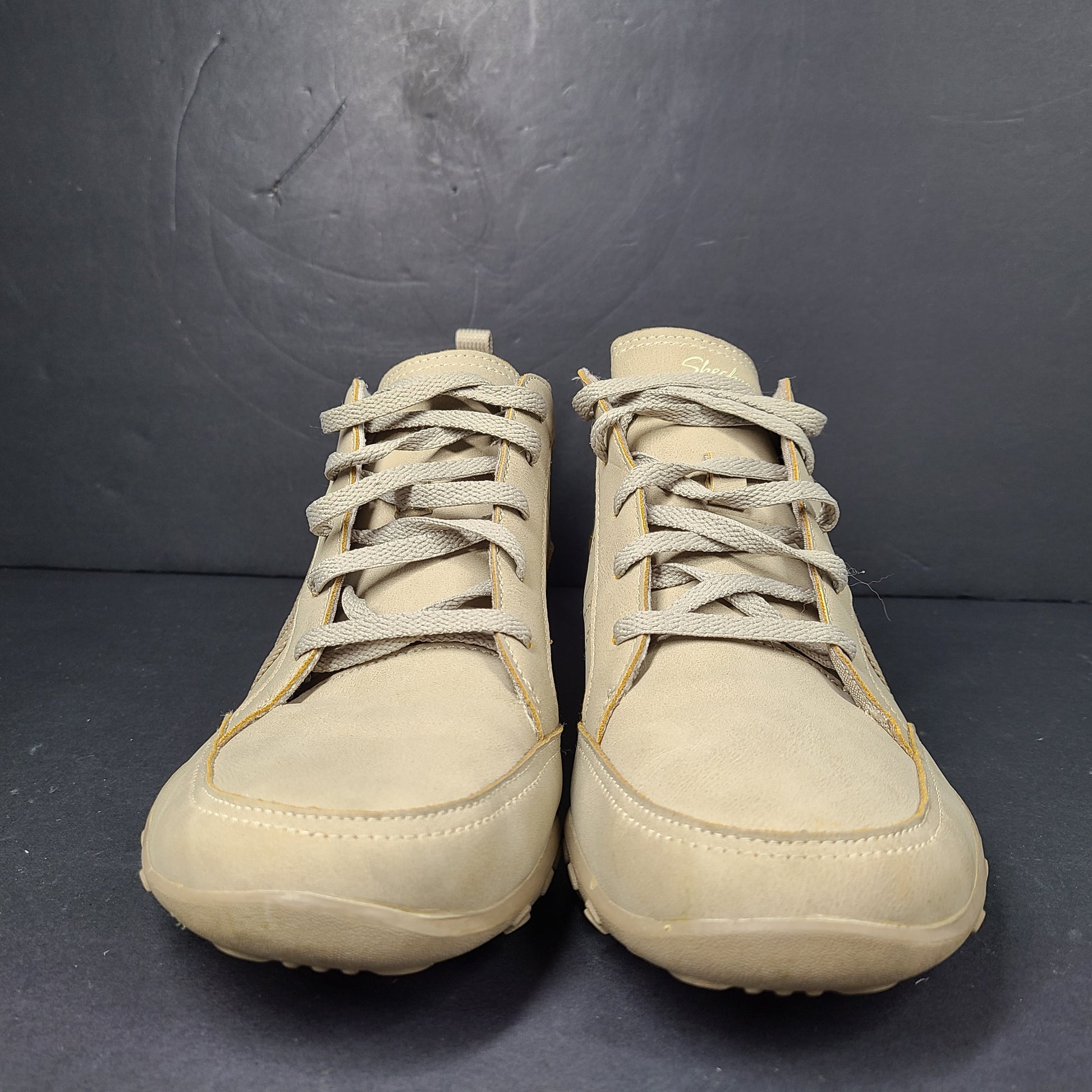 A pair of beige Skechers women's sneakers with a relaxed fit design.