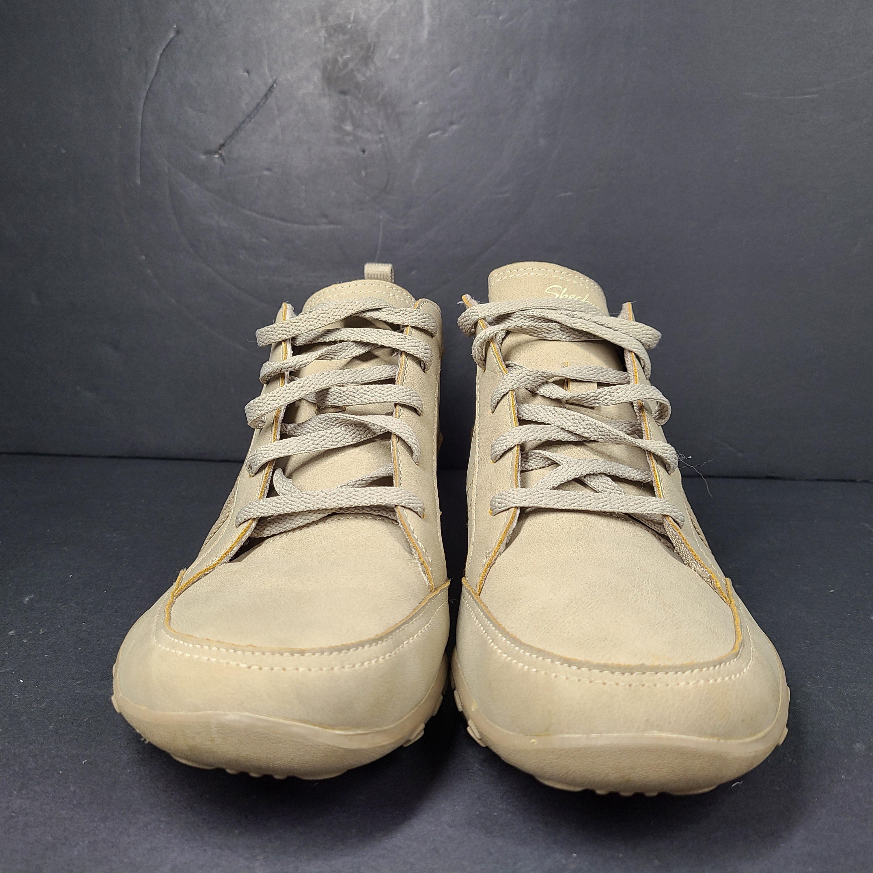 A pair of beige Skechers women's sneakers with a relaxed fit design.