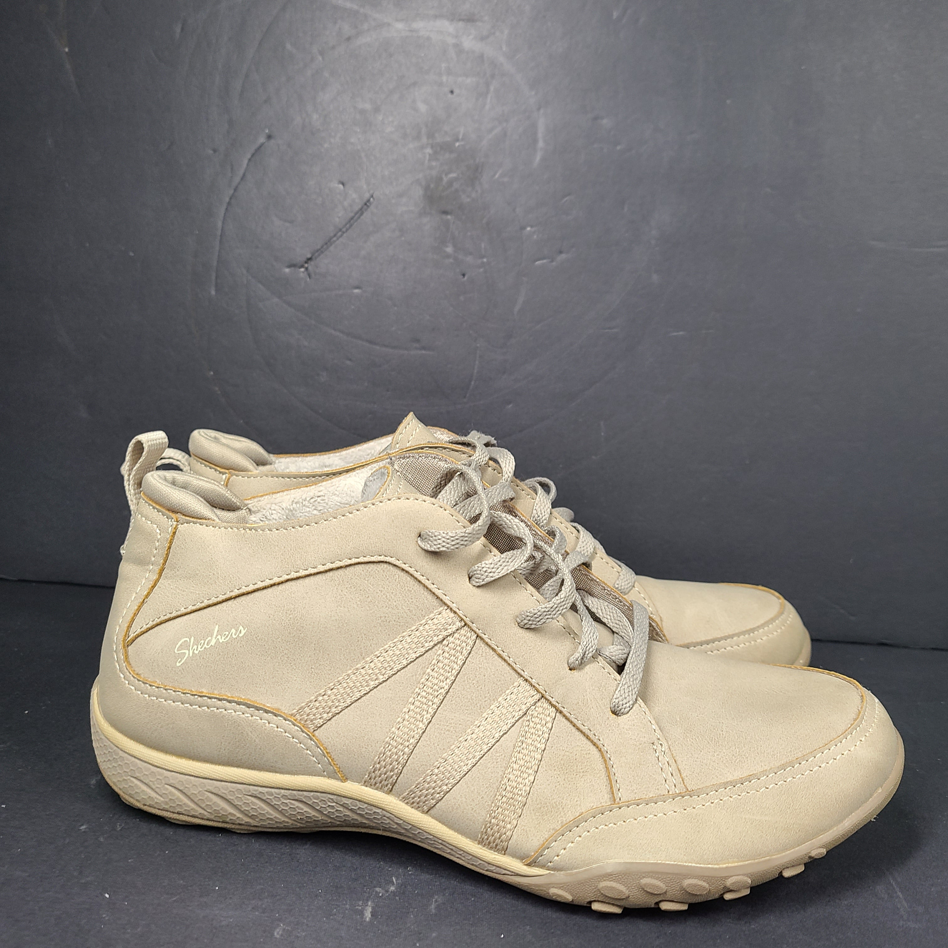 A pair of beige Skechers women's sneakers with a relaxed fit design.