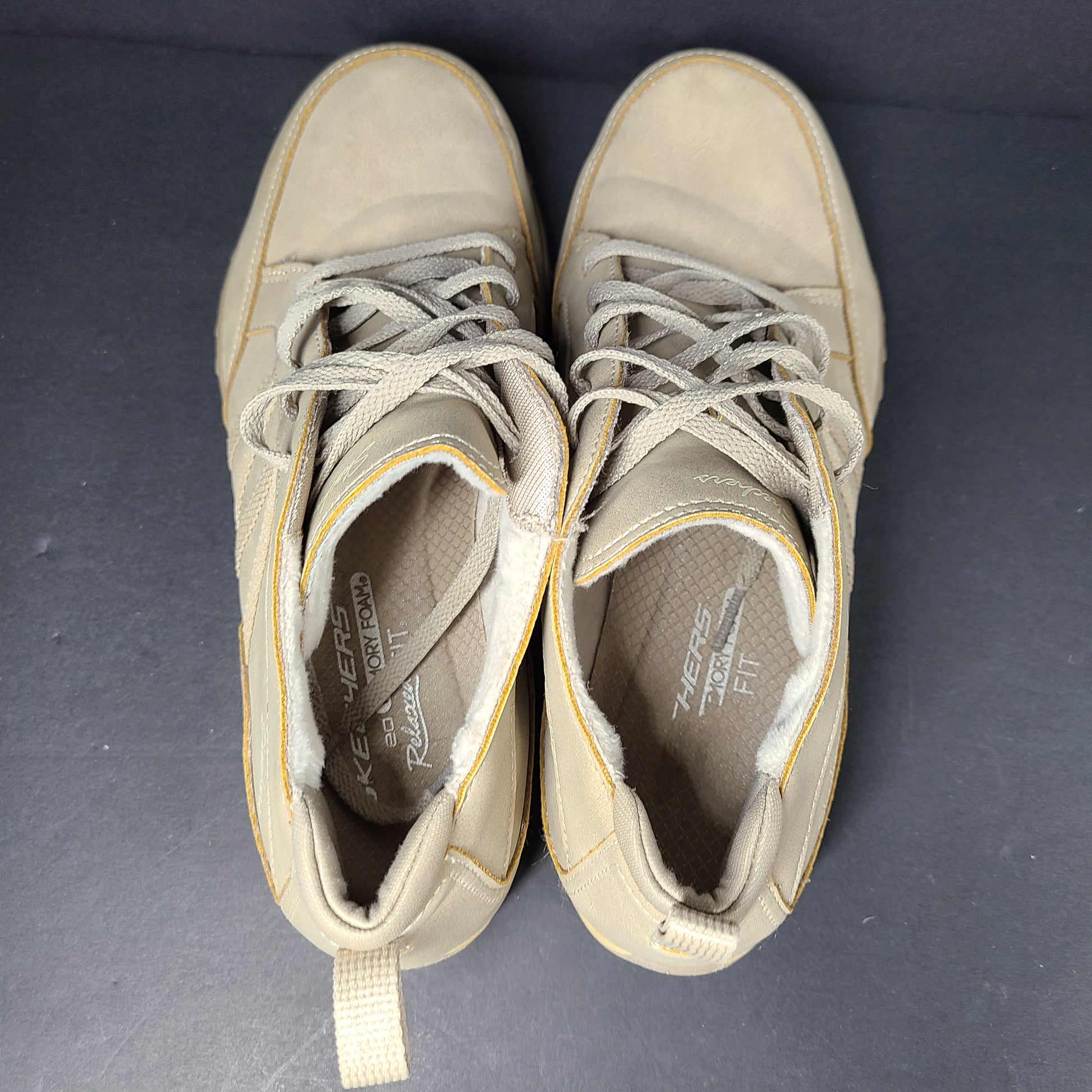 A pair of beige Skechers women's sneakers with a relaxed fit design.
