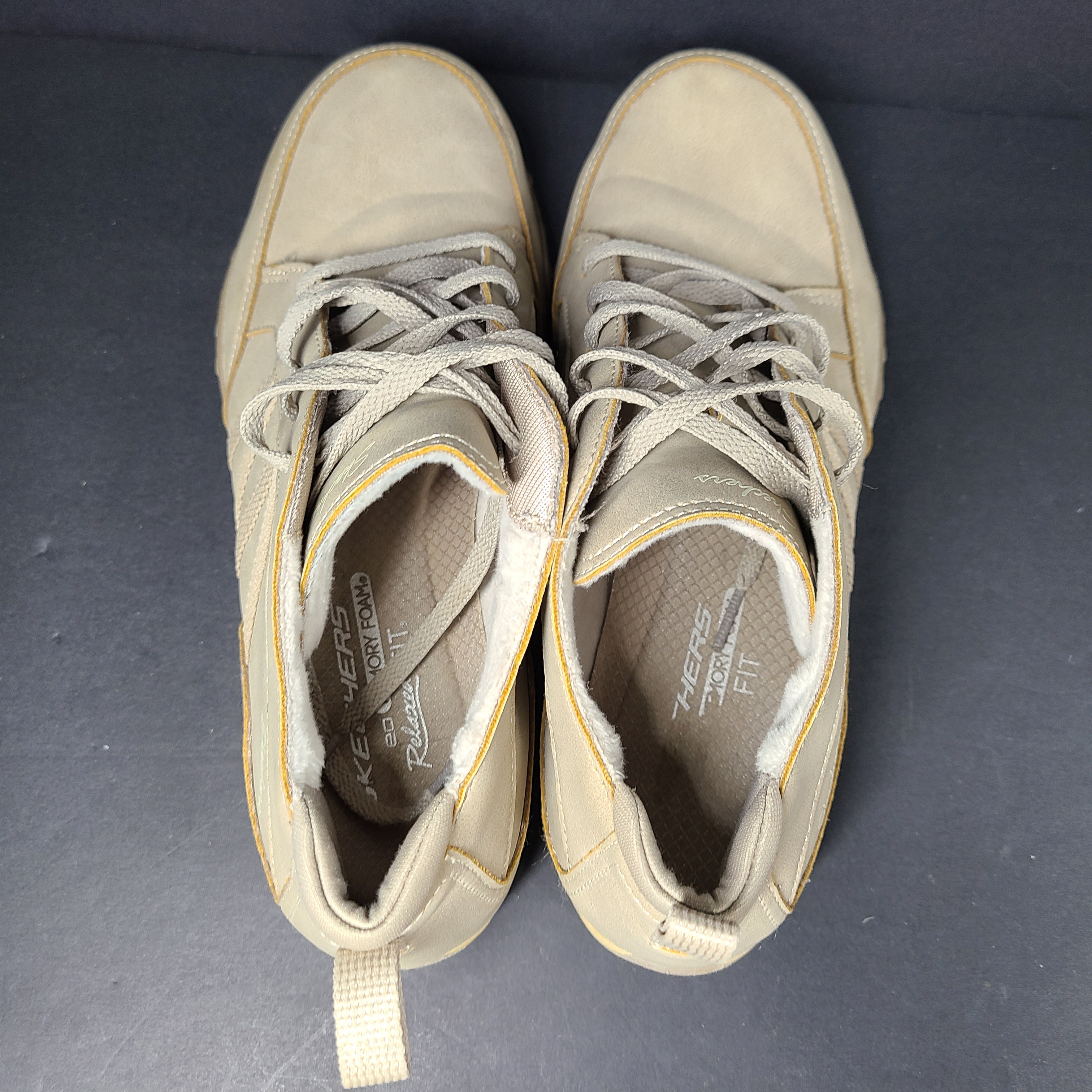 A pair of beige Skechers women's sneakers with a relaxed fit design.