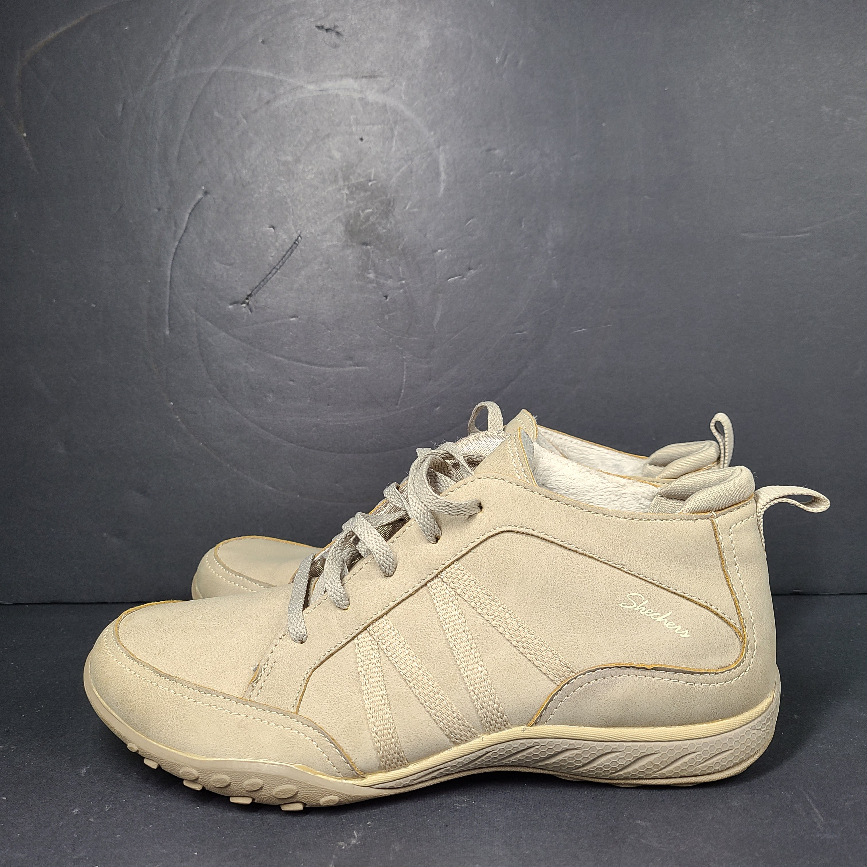 A pair of beige Skechers women's sneakers with a relaxed fit design.