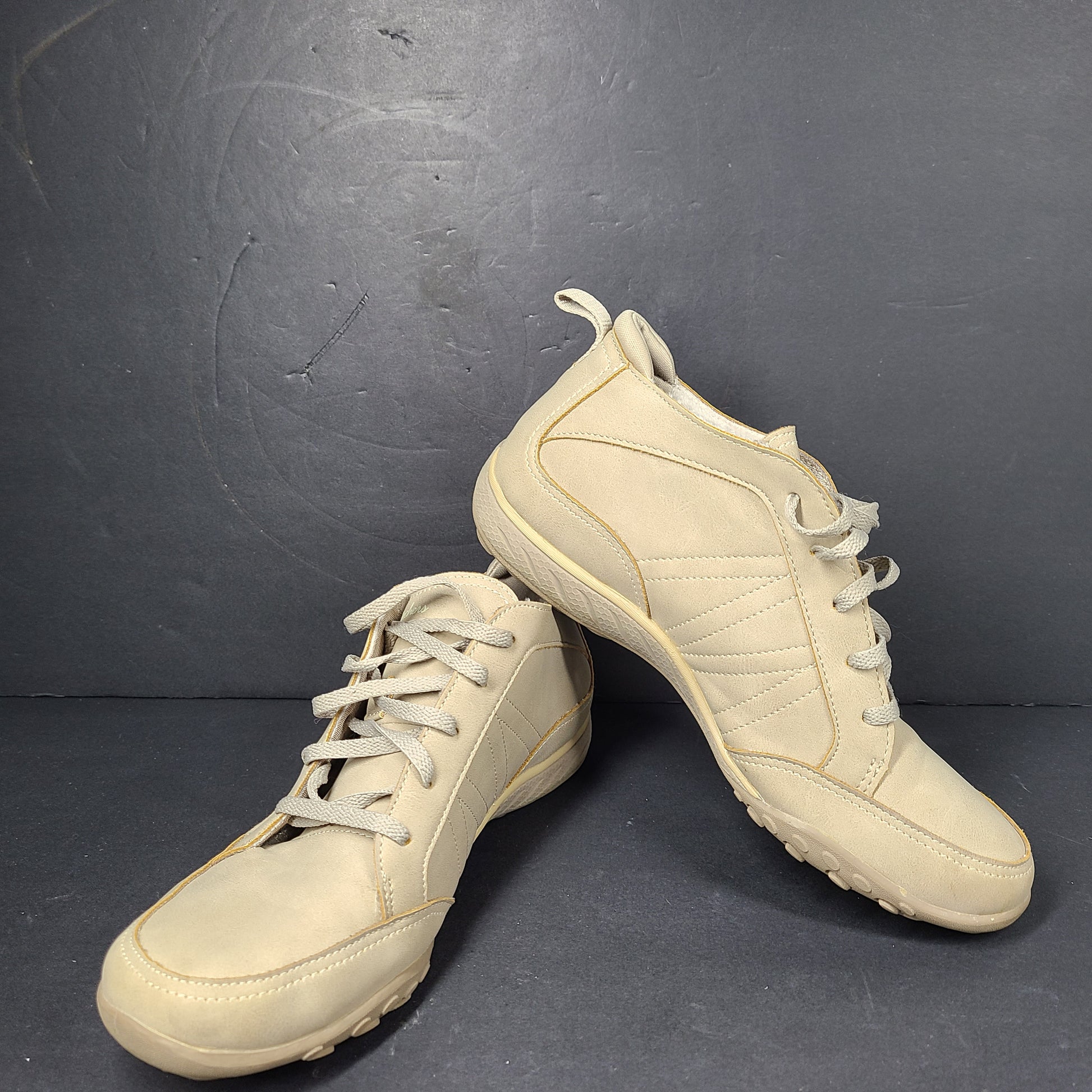 A pair of beige Skechers women's sneakers with a relaxed fit design.