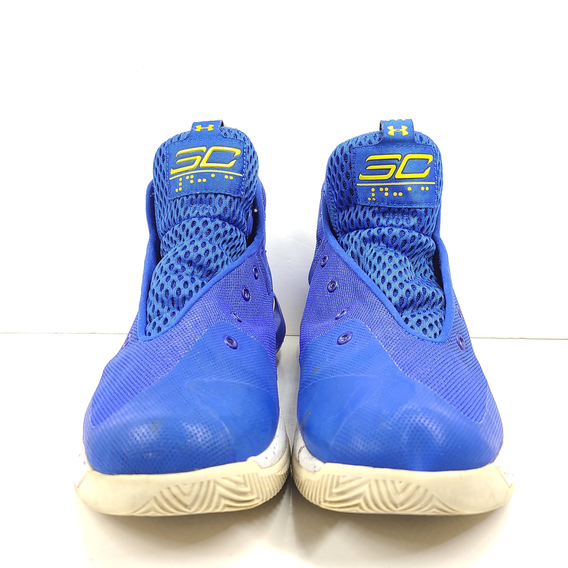 A pair of blue and yellow Under Armour basketball sneakers