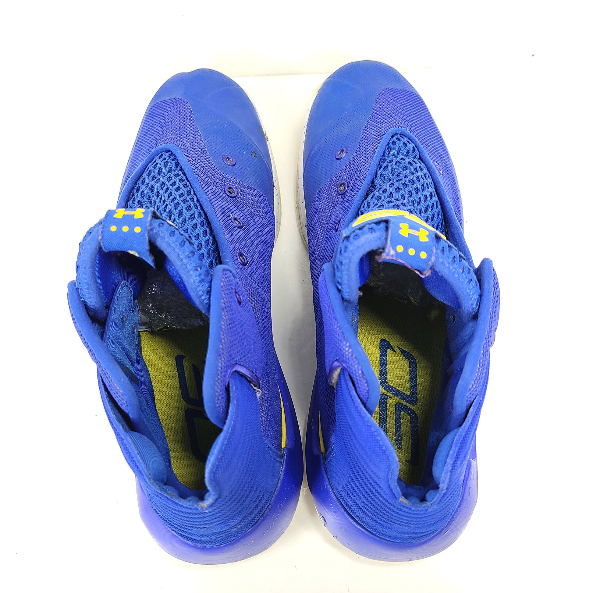 A pair of blue and yellow Under Armour basketball sneakers