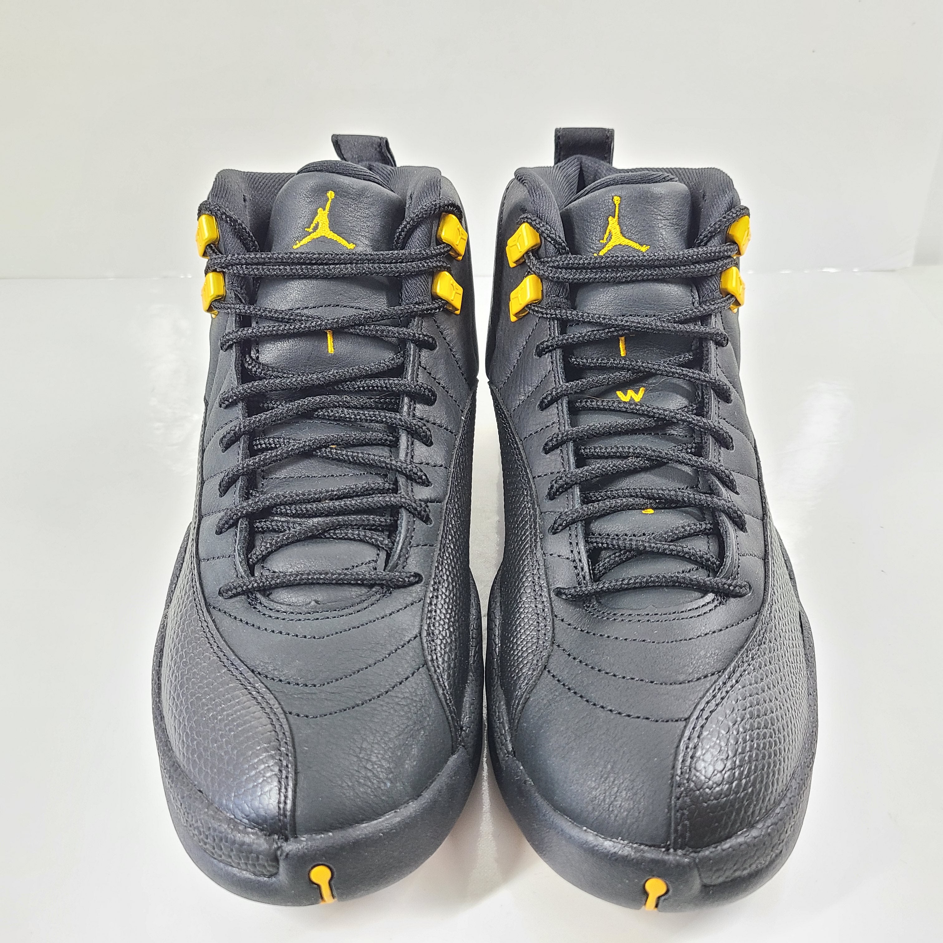 A pair of black and yellow Nike Air Jordan 12 Retro sneakers
