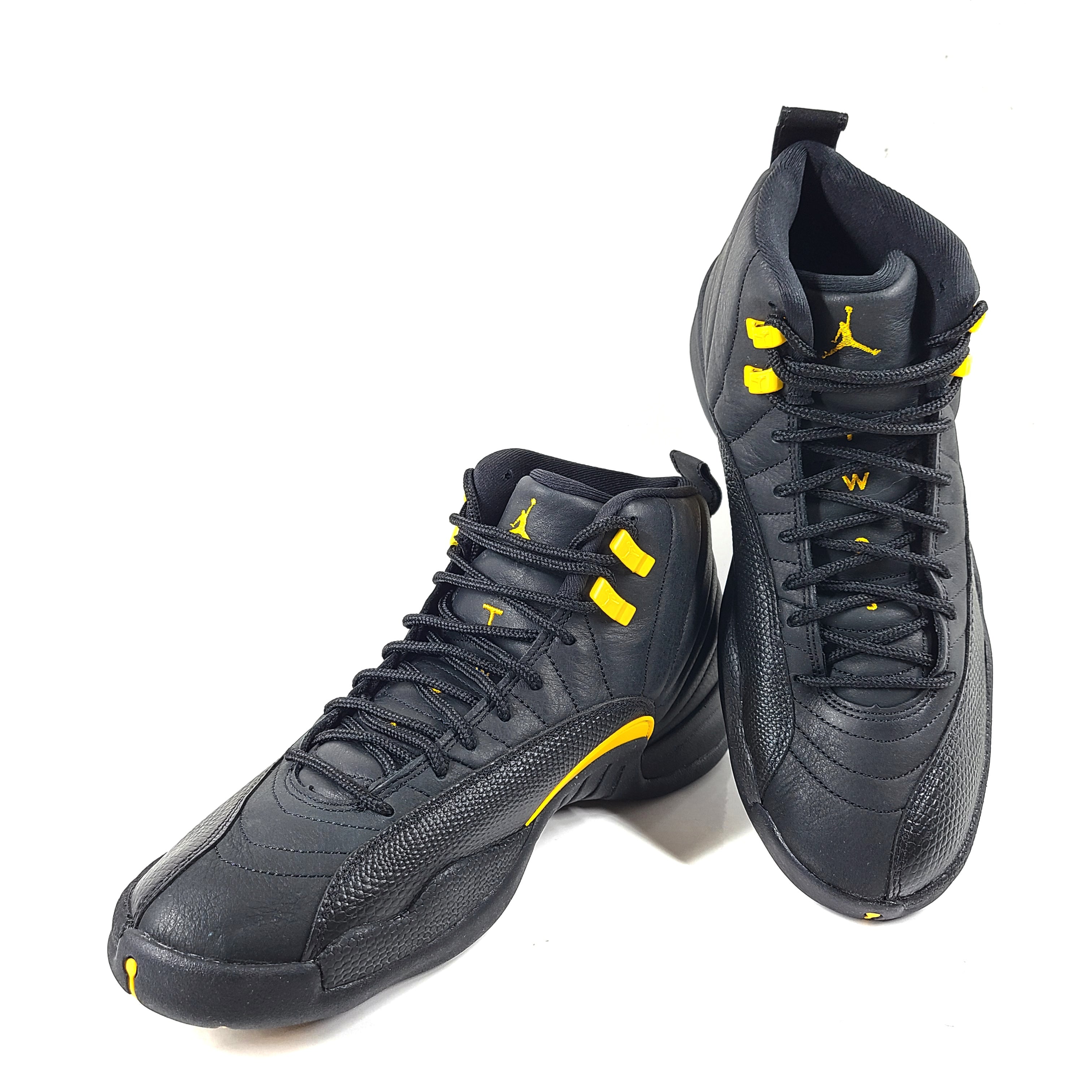 A pair of black and yellow Nike Air Jordan 12 Retro sneakers