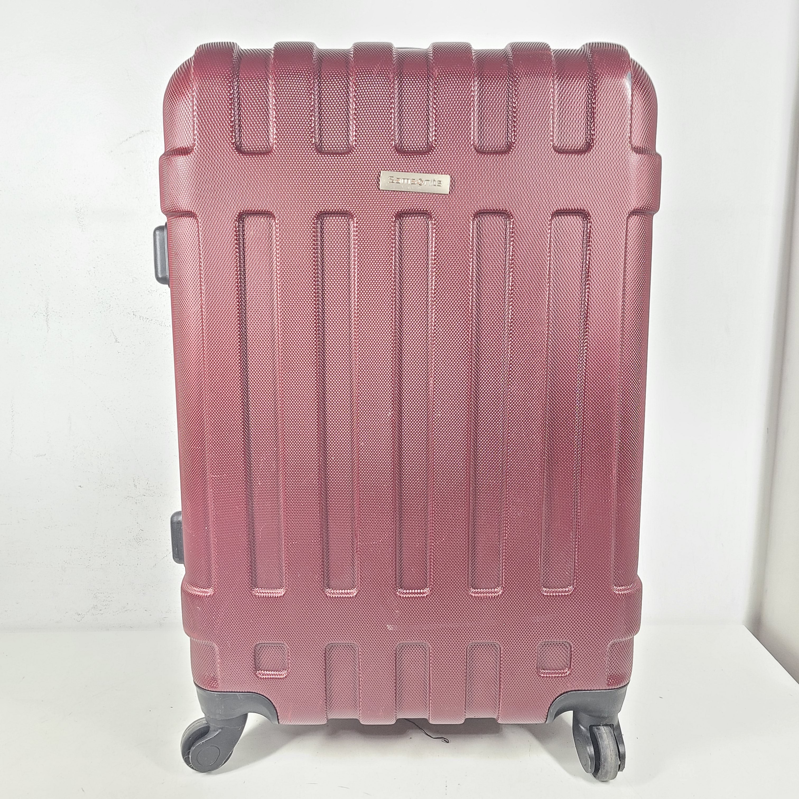 A burgundy Samsonite hardside spinner suitcase