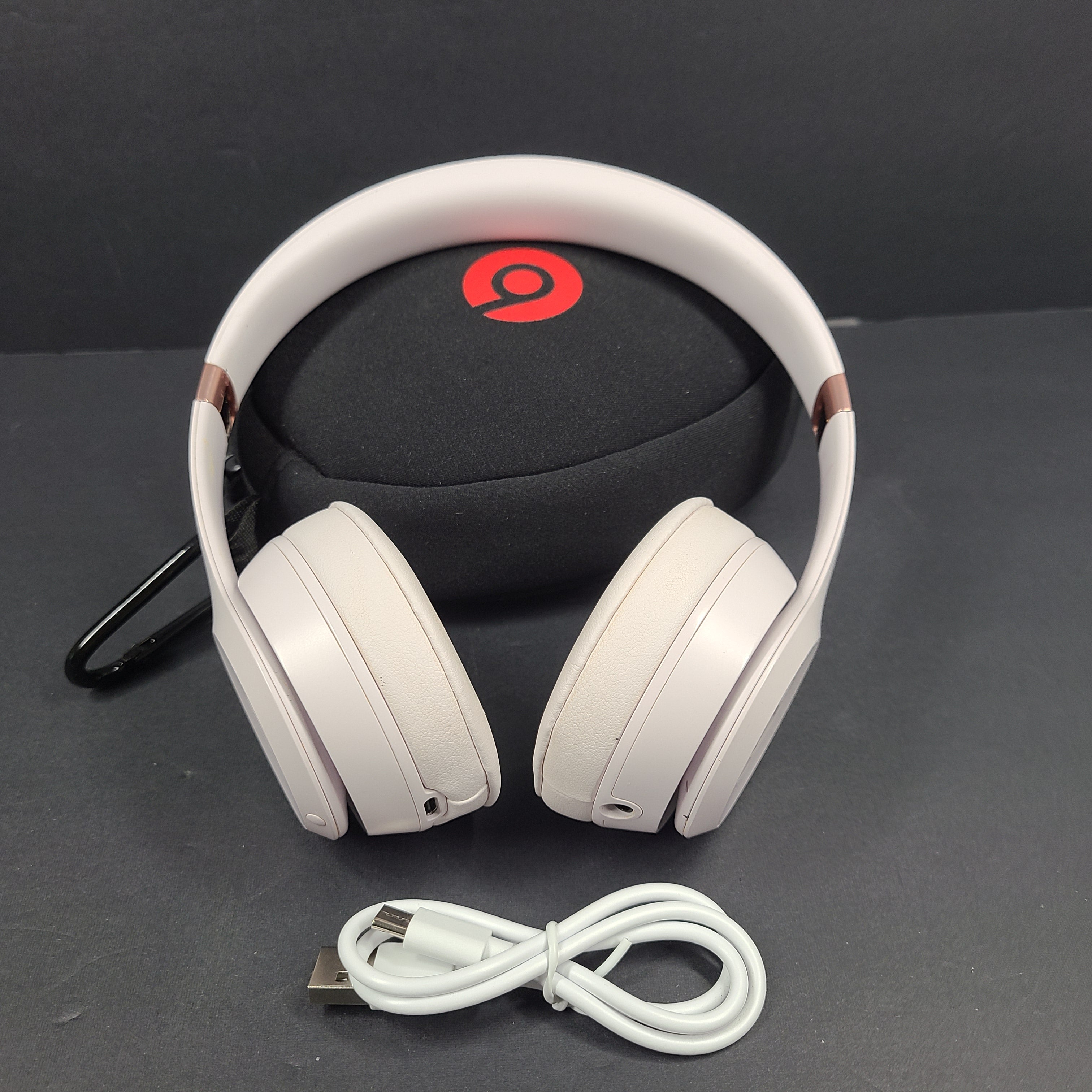 A pair of stylish on-ear headphones in white and rose gold