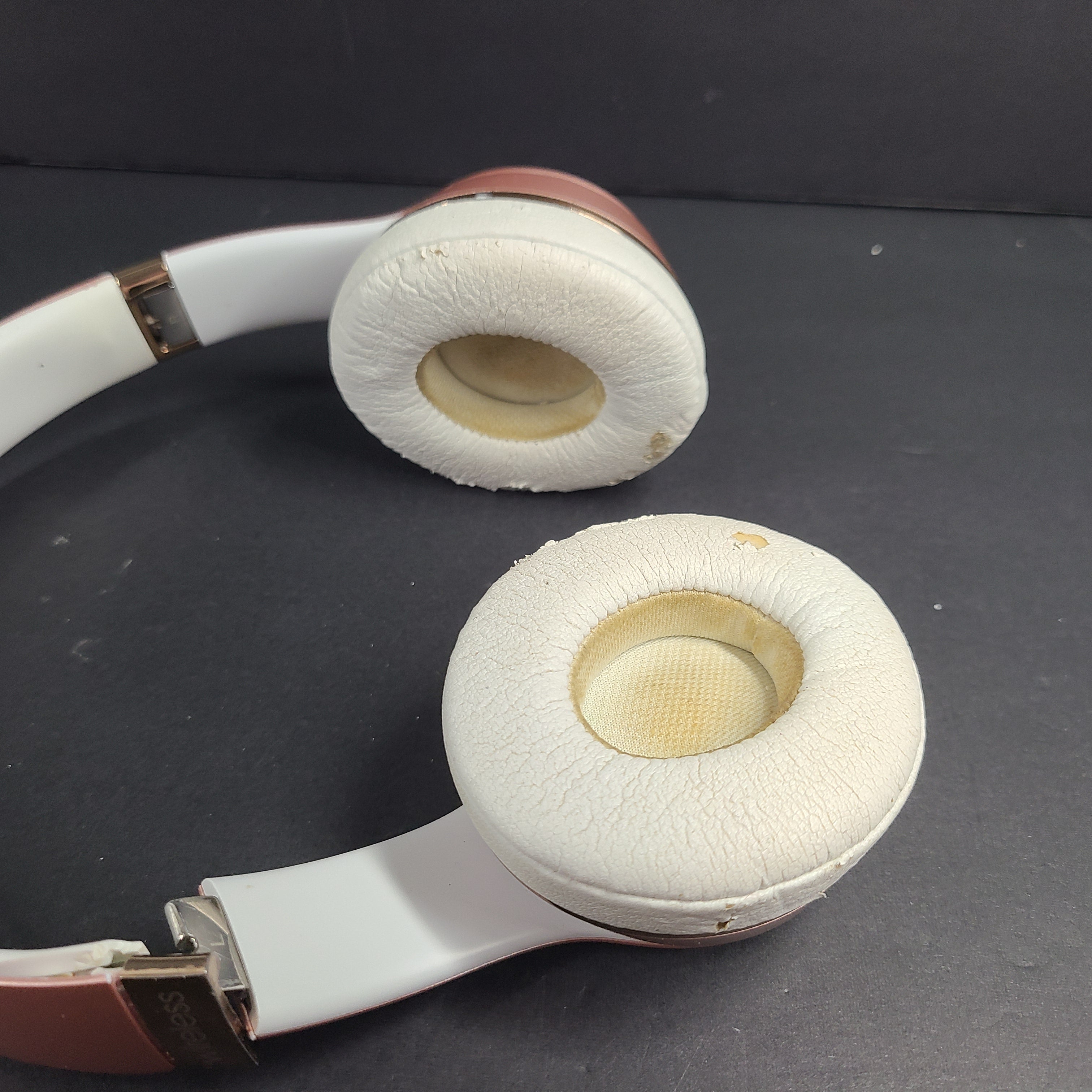 A stylish pair of rose gold wireless on-ear headphones offering premium sound and long-lasting comfort