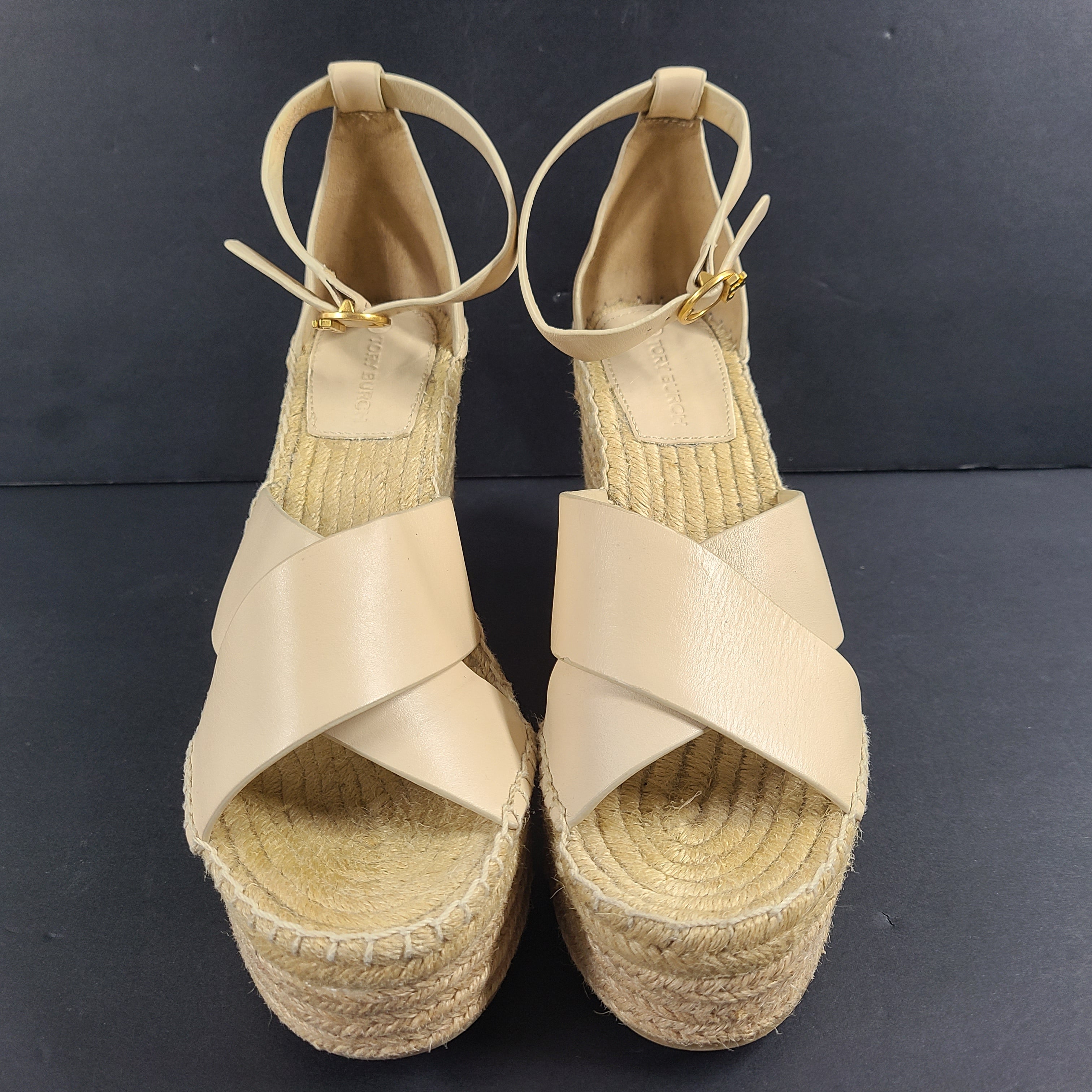 A pair of beige Tory Burch leather espadrille wedge sandals in size 9M.