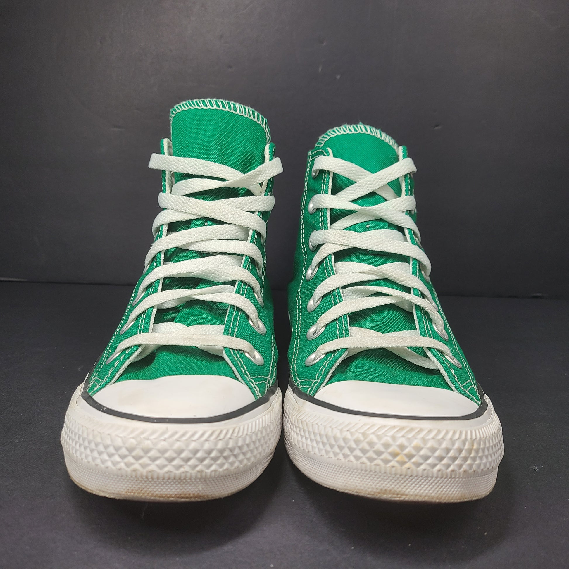 A pair of green Converse All Star high top sneakers for men and women.