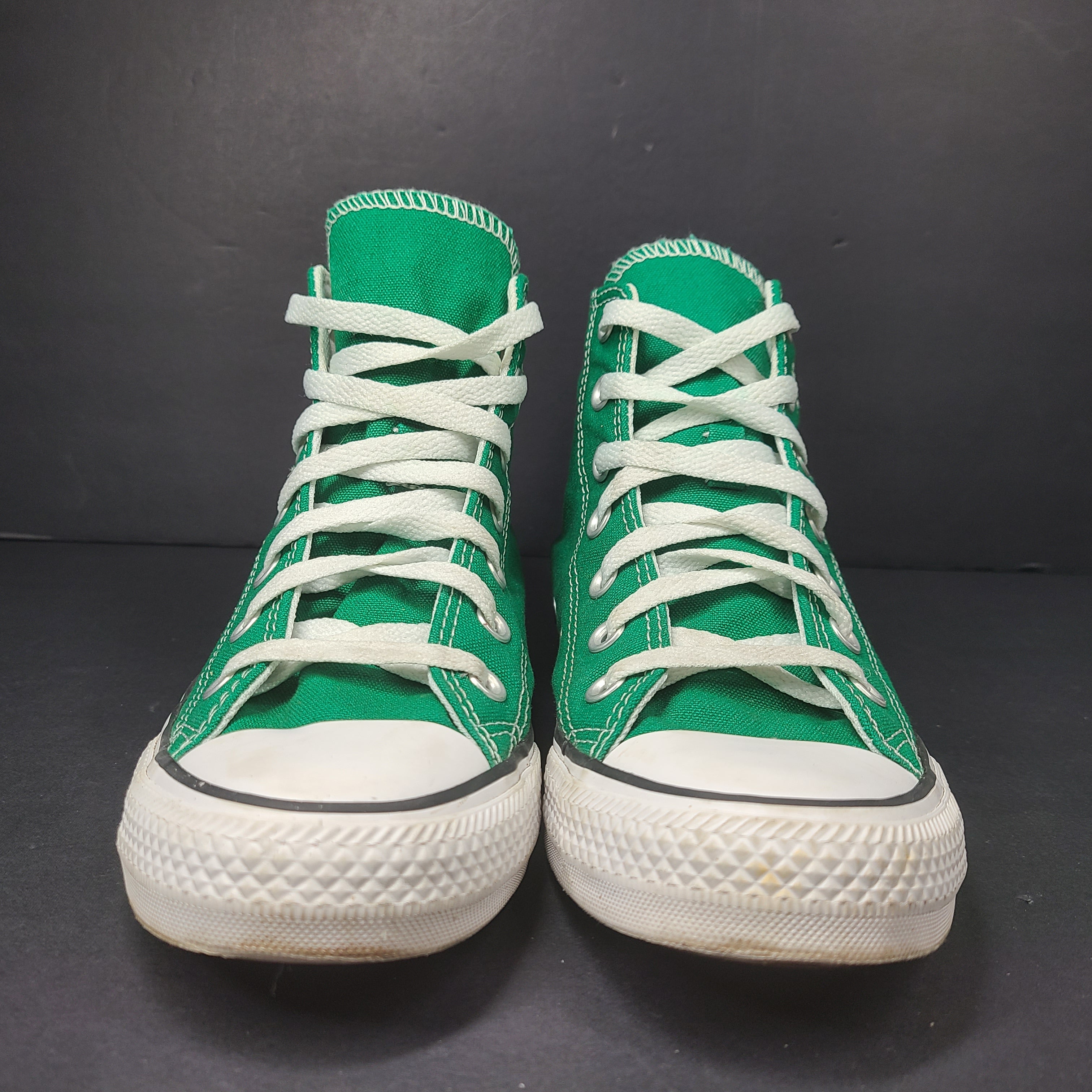 A pair of green Converse All Star high top sneakers for men and women.