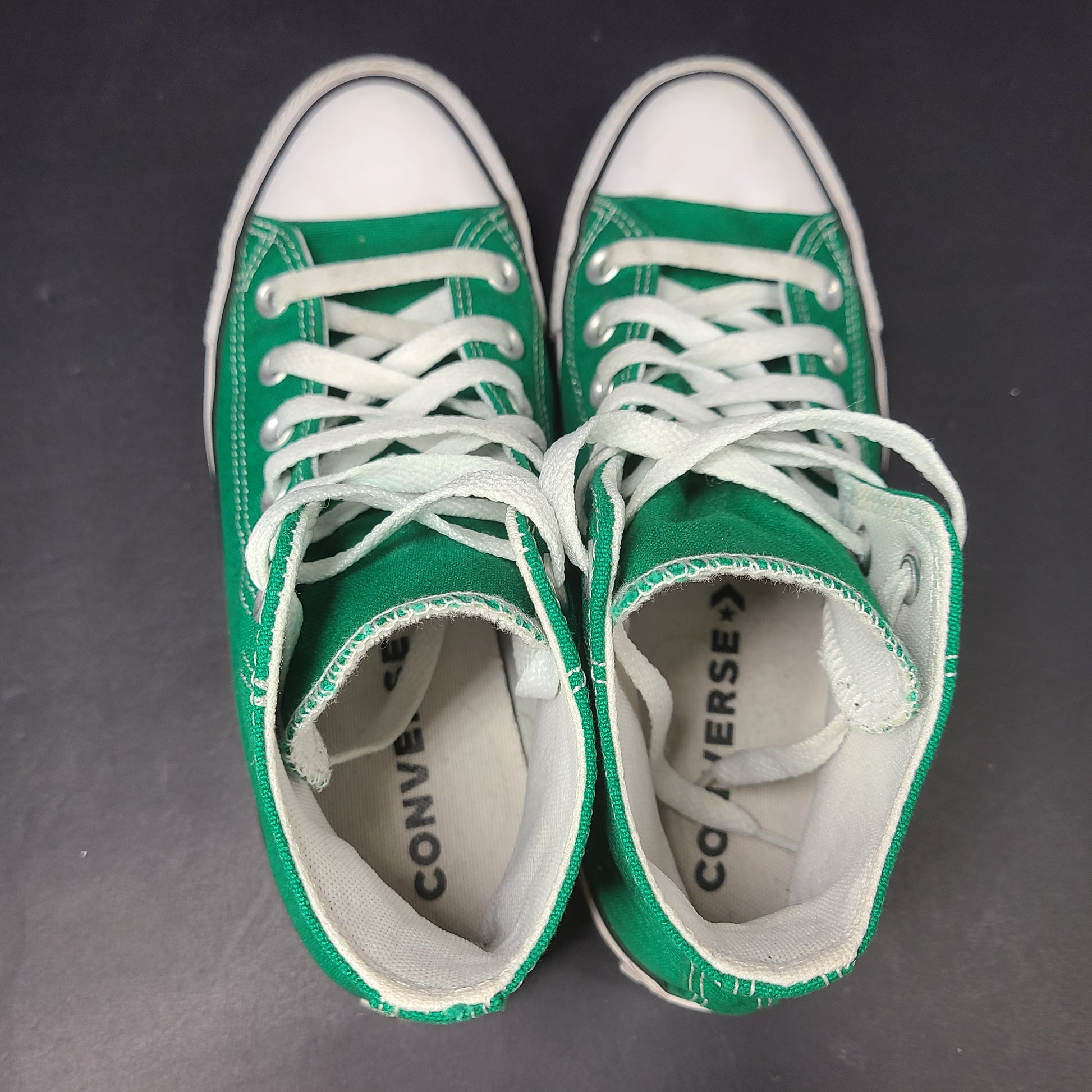 A pair of green Converse All Star high top sneakers for men and women.