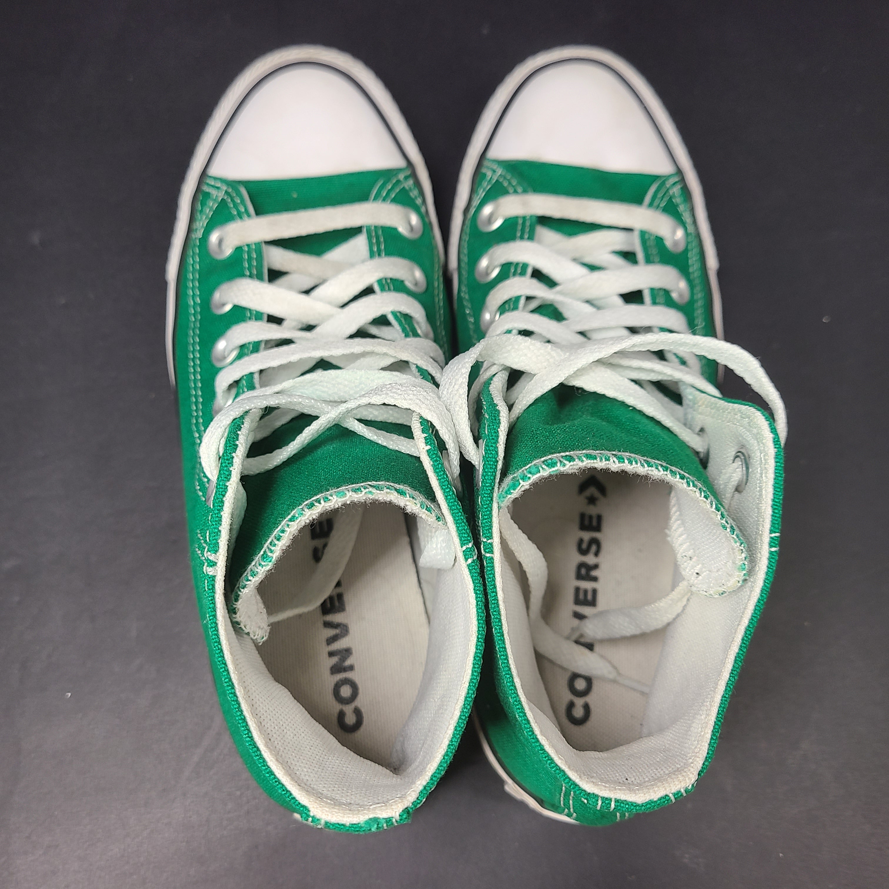 A pair of green Converse All Star high top sneakers for men and women.