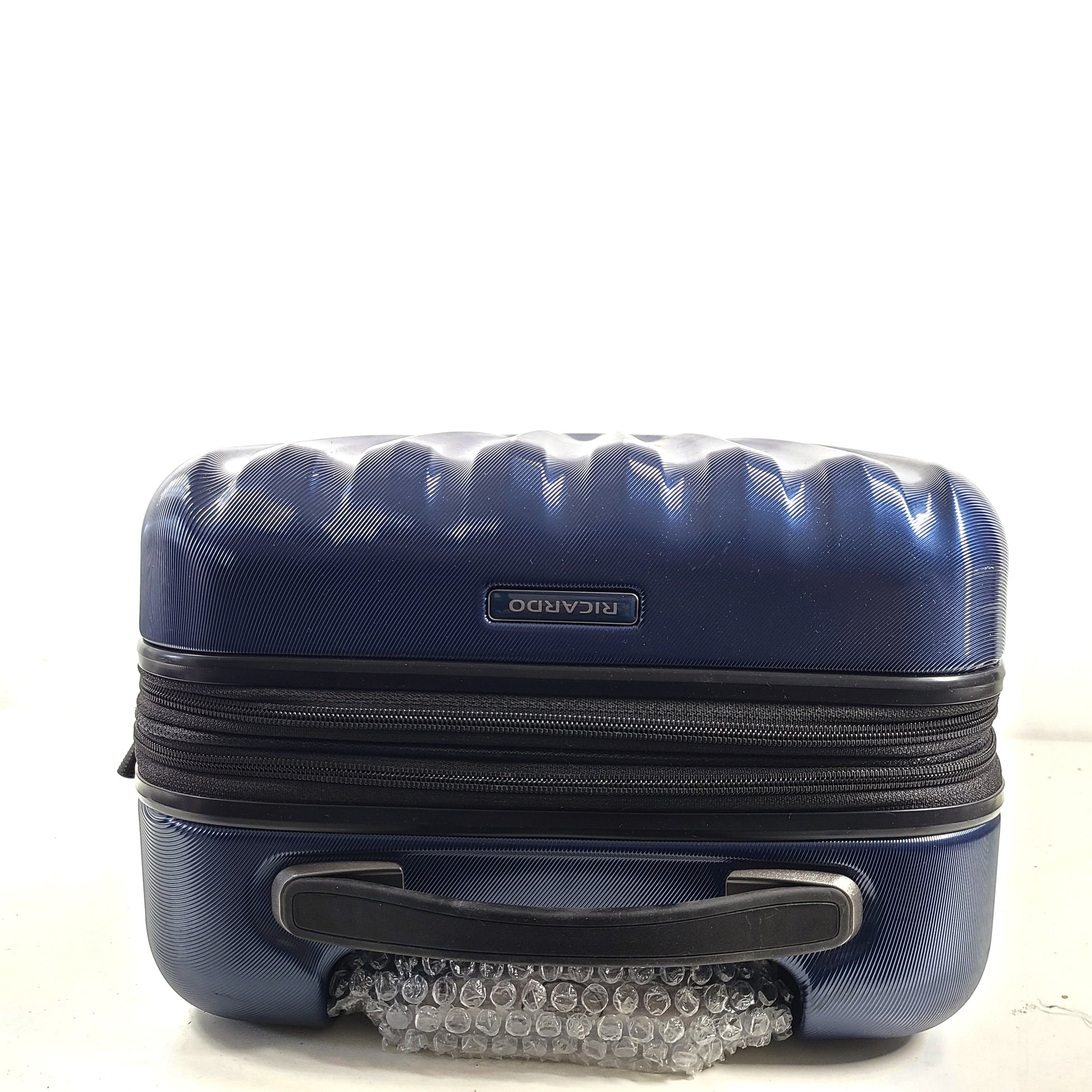 A sleek blue spinner luggage by Ricardo Beverly Hills.
