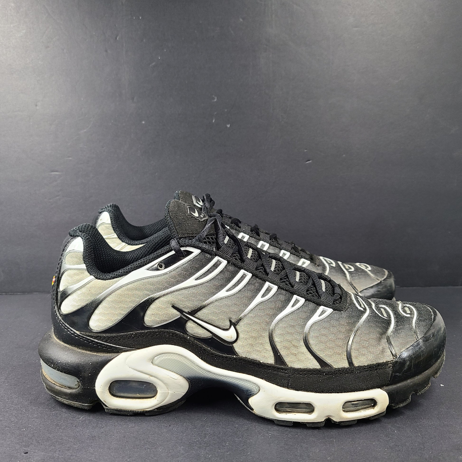 A pair of stylish Nike Air Max Plus Tn DM0032-003 Black/White Men's Shoes Size 8.5