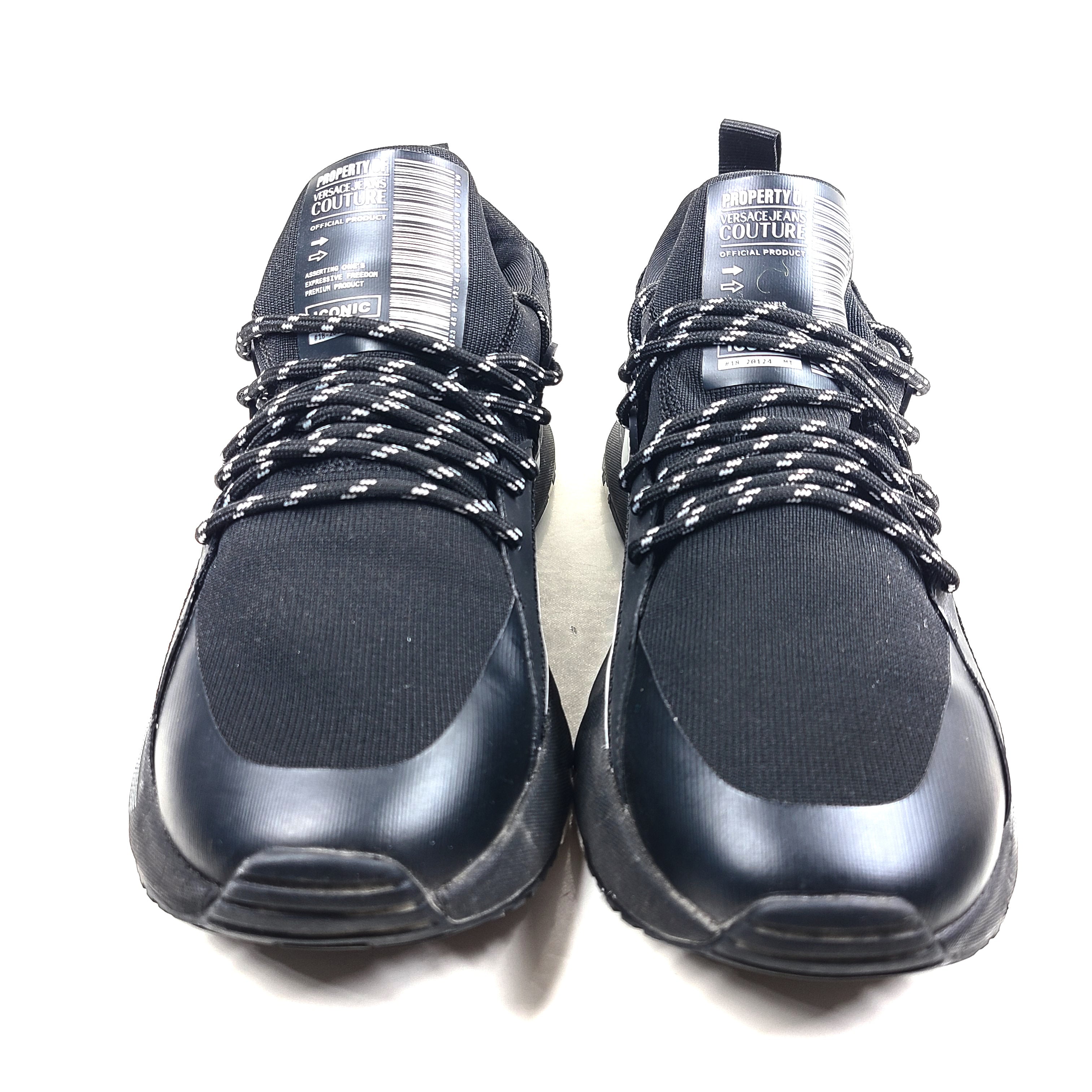 A pair of Versace Jeans Couture black sneakers with slight wear.
