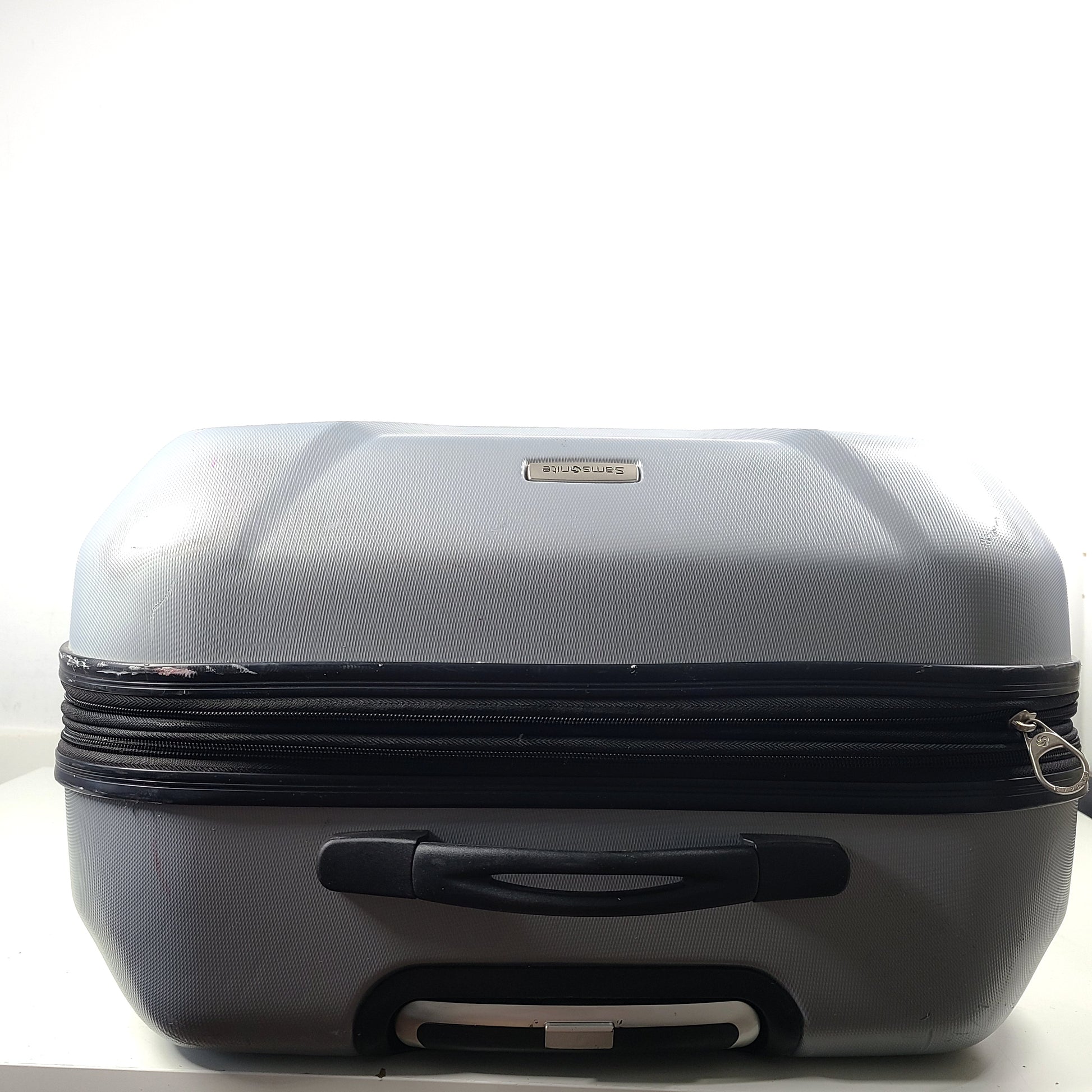A silver hard shell Samsonite 4-wheel suitcase.
