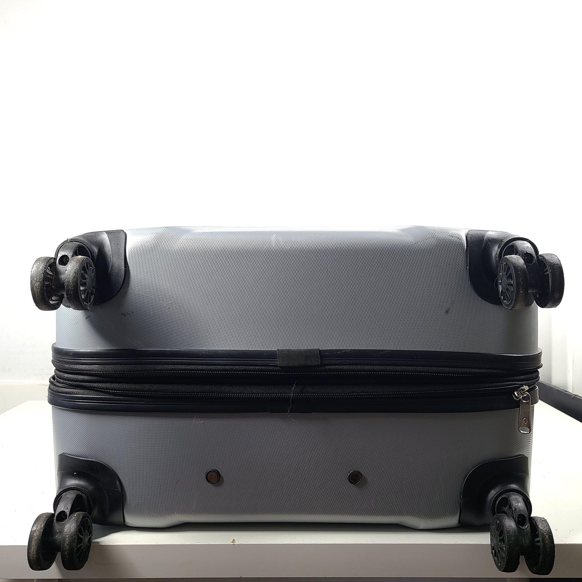 A silver hard shell Samsonite 4-wheel suitcase.