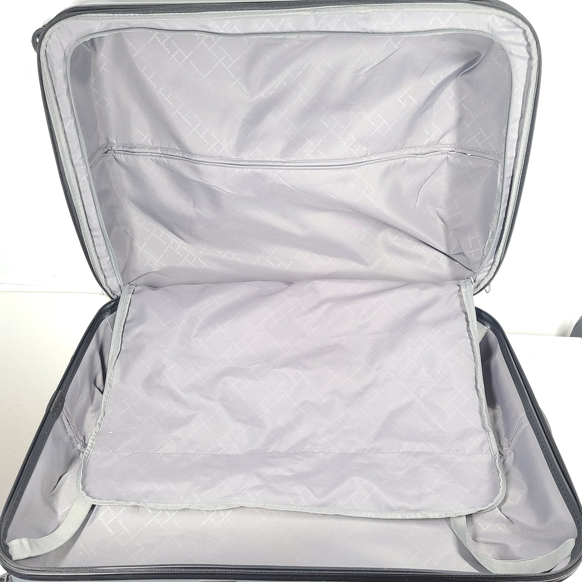 A silver hard shell Samsonite 4-wheel suitcase.