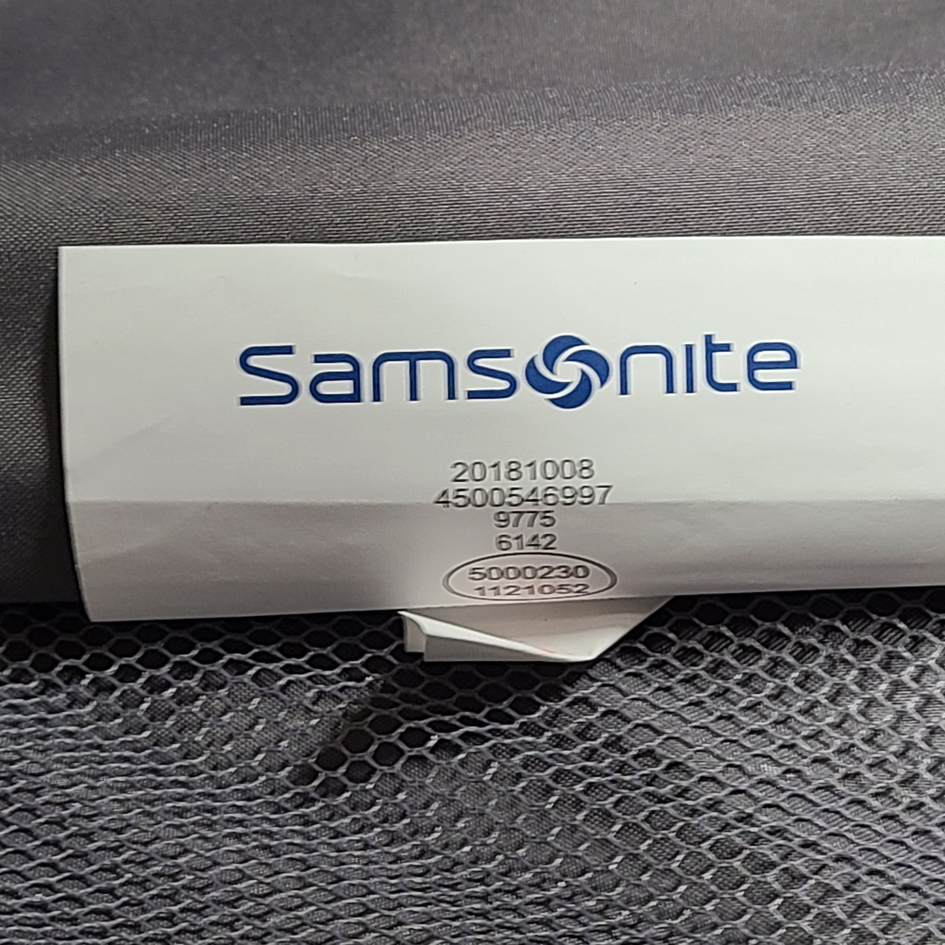 A silver hard shell Samsonite 4-wheel suitcase.