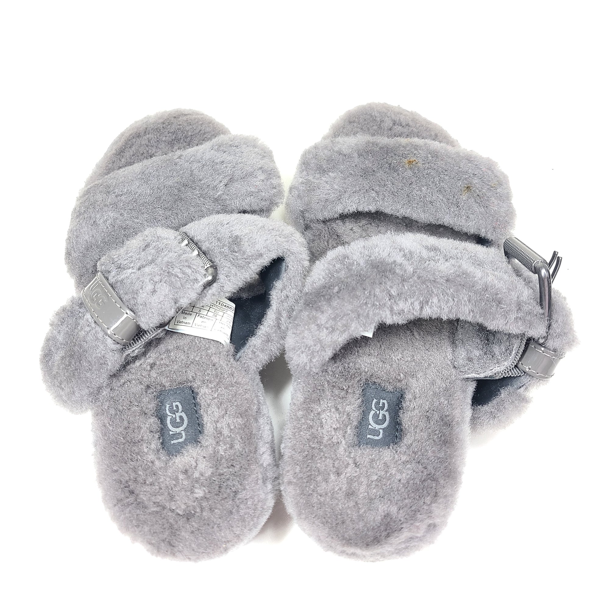 A pair of gray UGG Fluffy Sandals with adjustable straps in size 7.