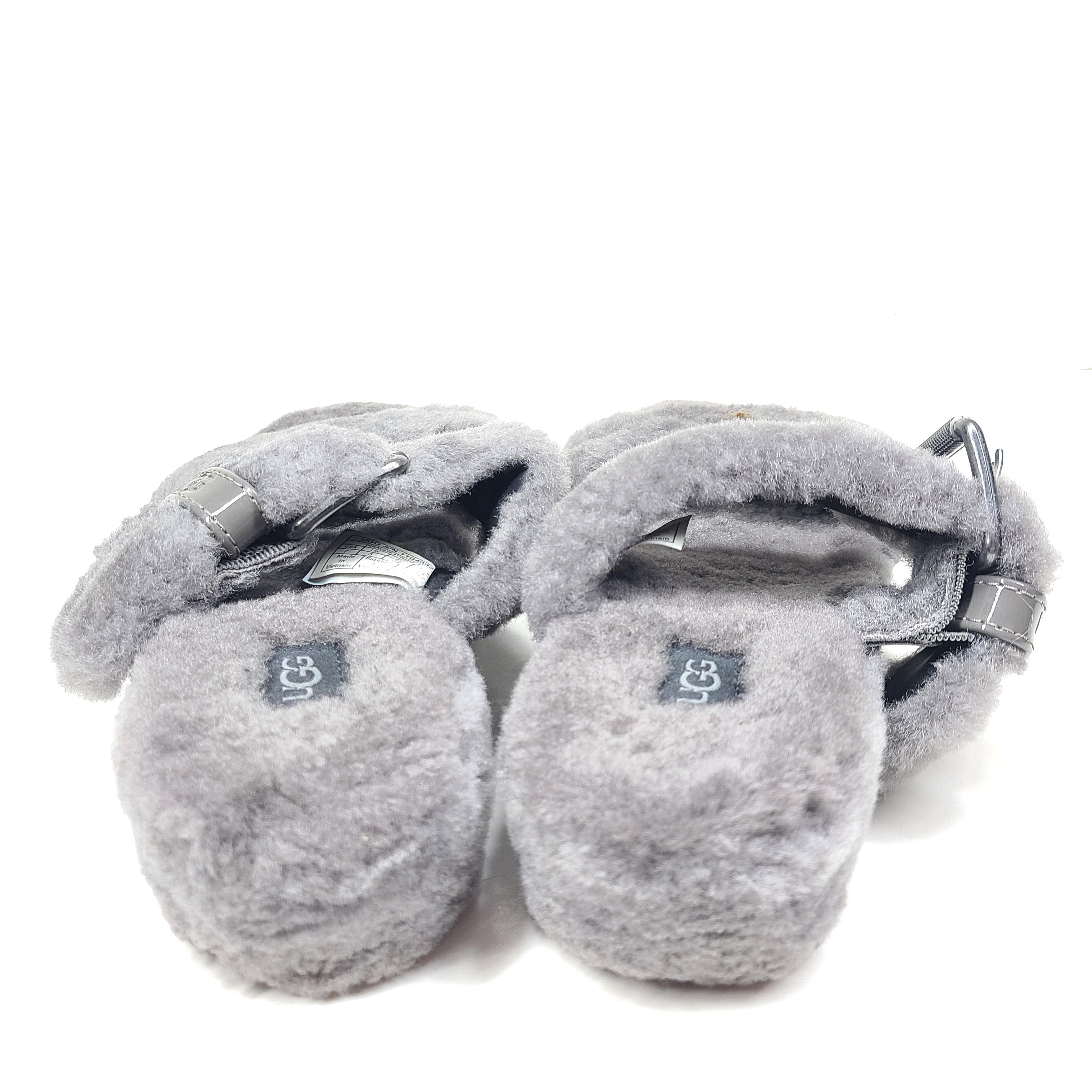 A pair of gray UGG Fluffy Sandals with adjustable straps in size 7.