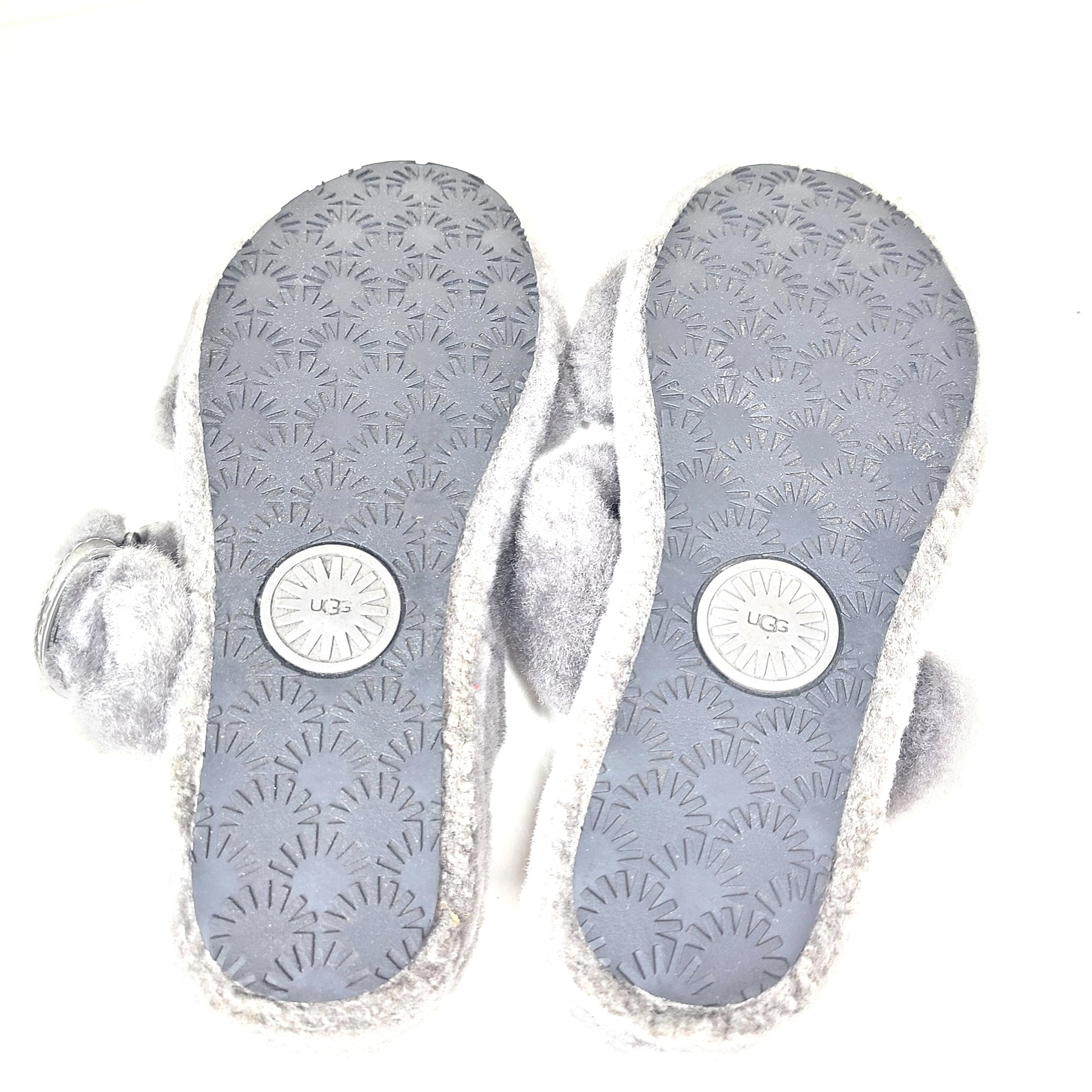 A pair of gray UGG Fluffy Sandals with adjustable straps in size 7.