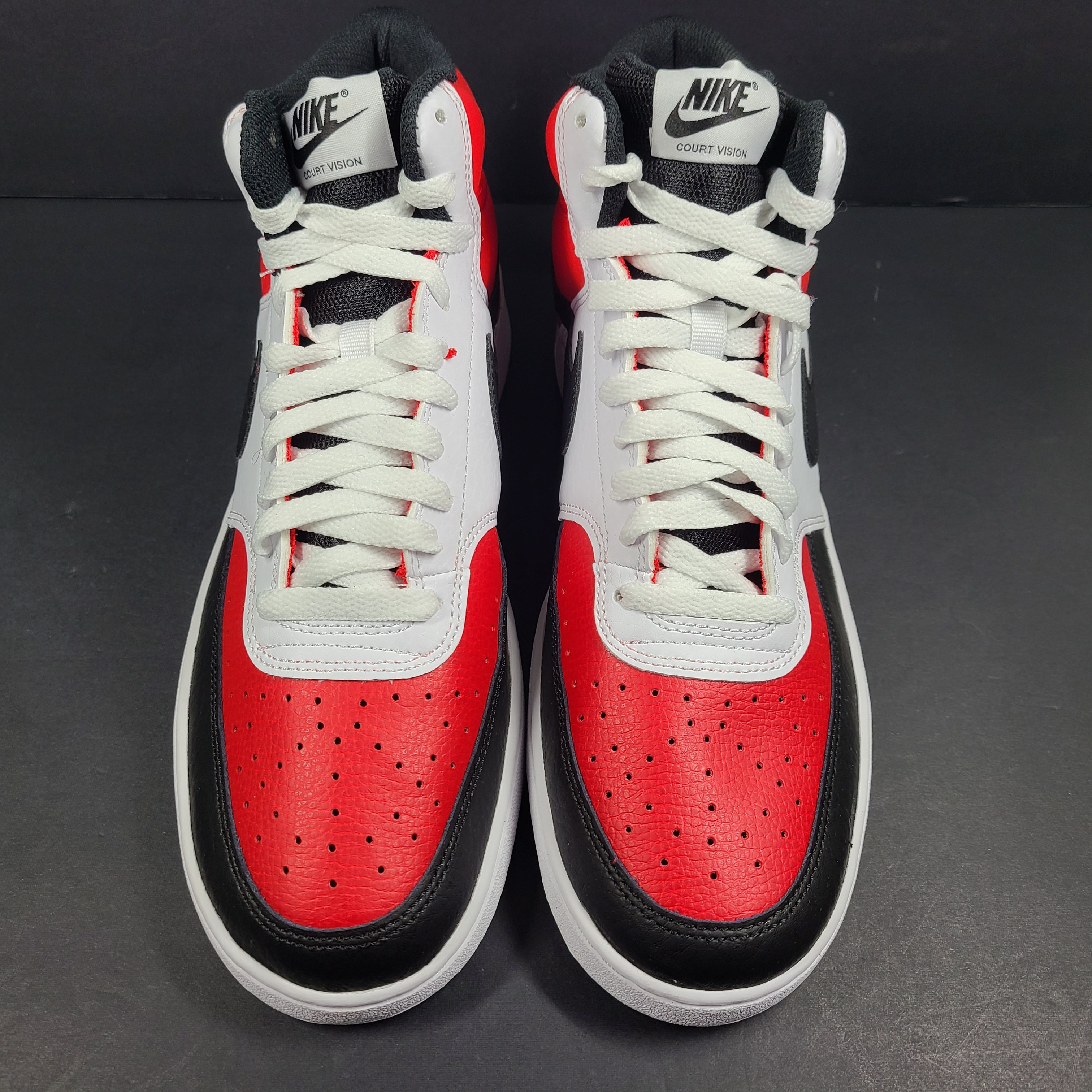 A pair of red, white, and black Nike Court Vision Mid sneakers
