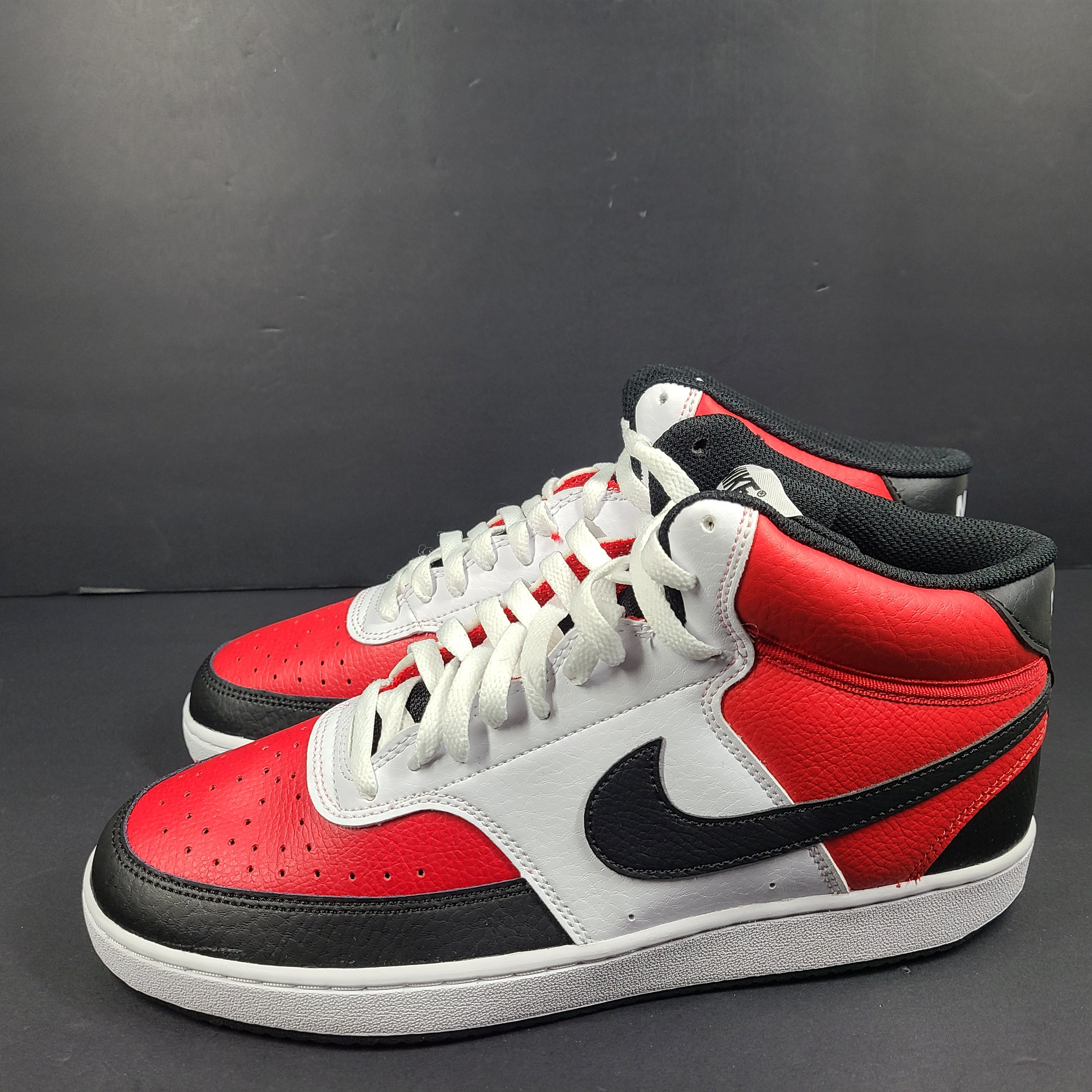 A pair of red, white, and black Nike Court Vision Mid sneakers