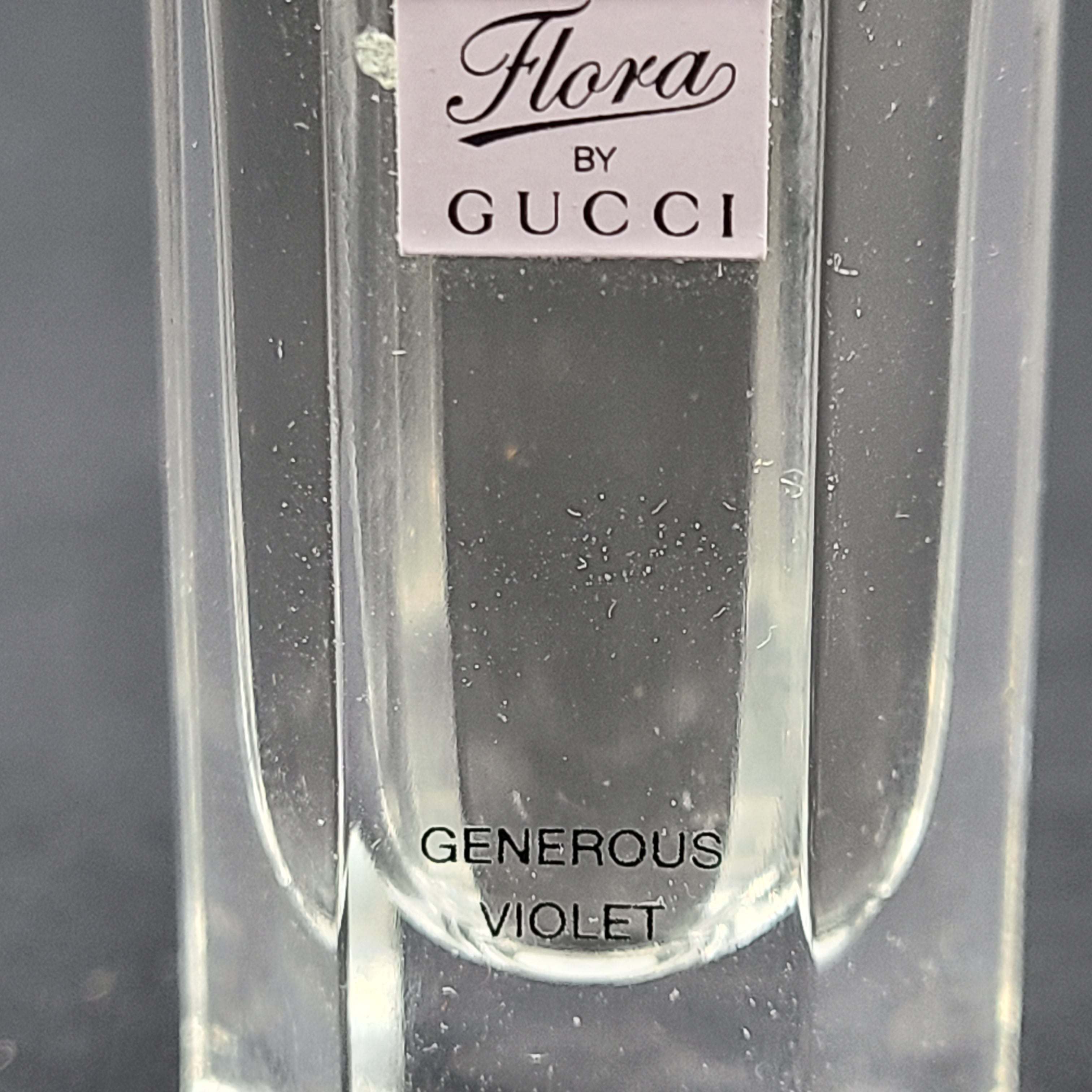 A small 5ml bottle of Gucci Flora Generous Violet Eau de Toilette perfume.